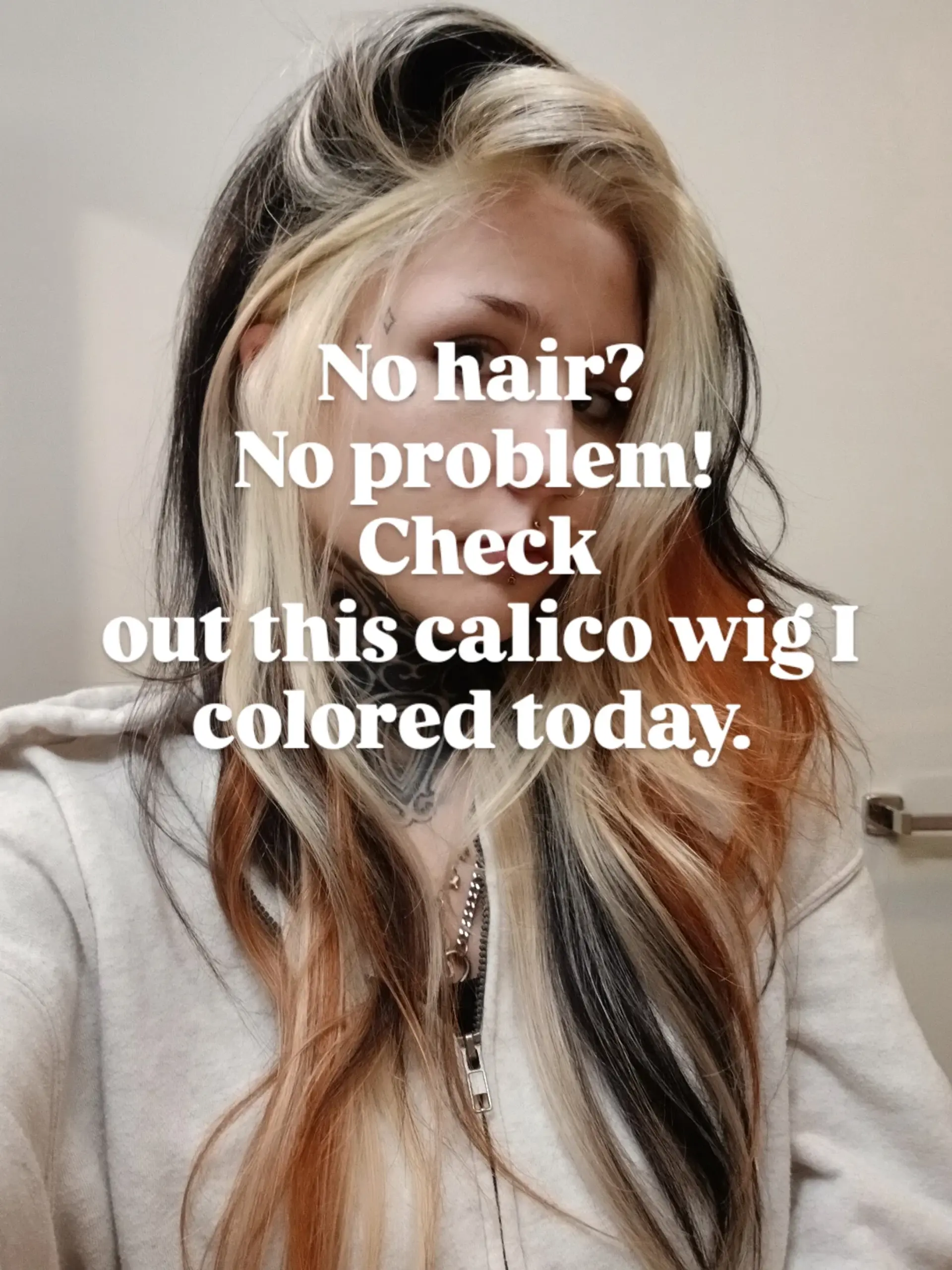 A bold calico hair color featuring contrasting blocks of platinum blonde, jet black, and warm copper styled in relaxed waves. 1