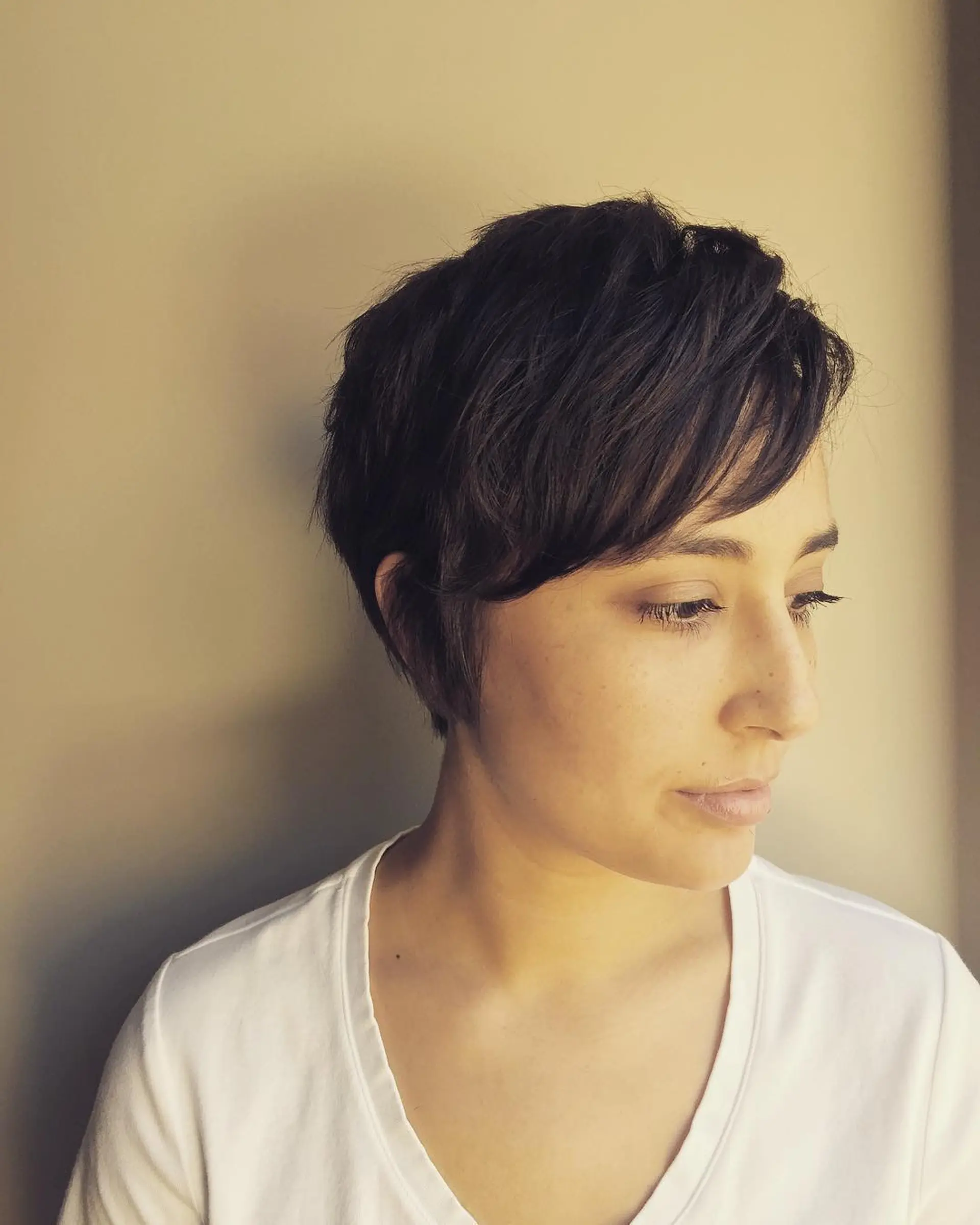 A short, textured pixie cut with soft bangs and layered details. 1