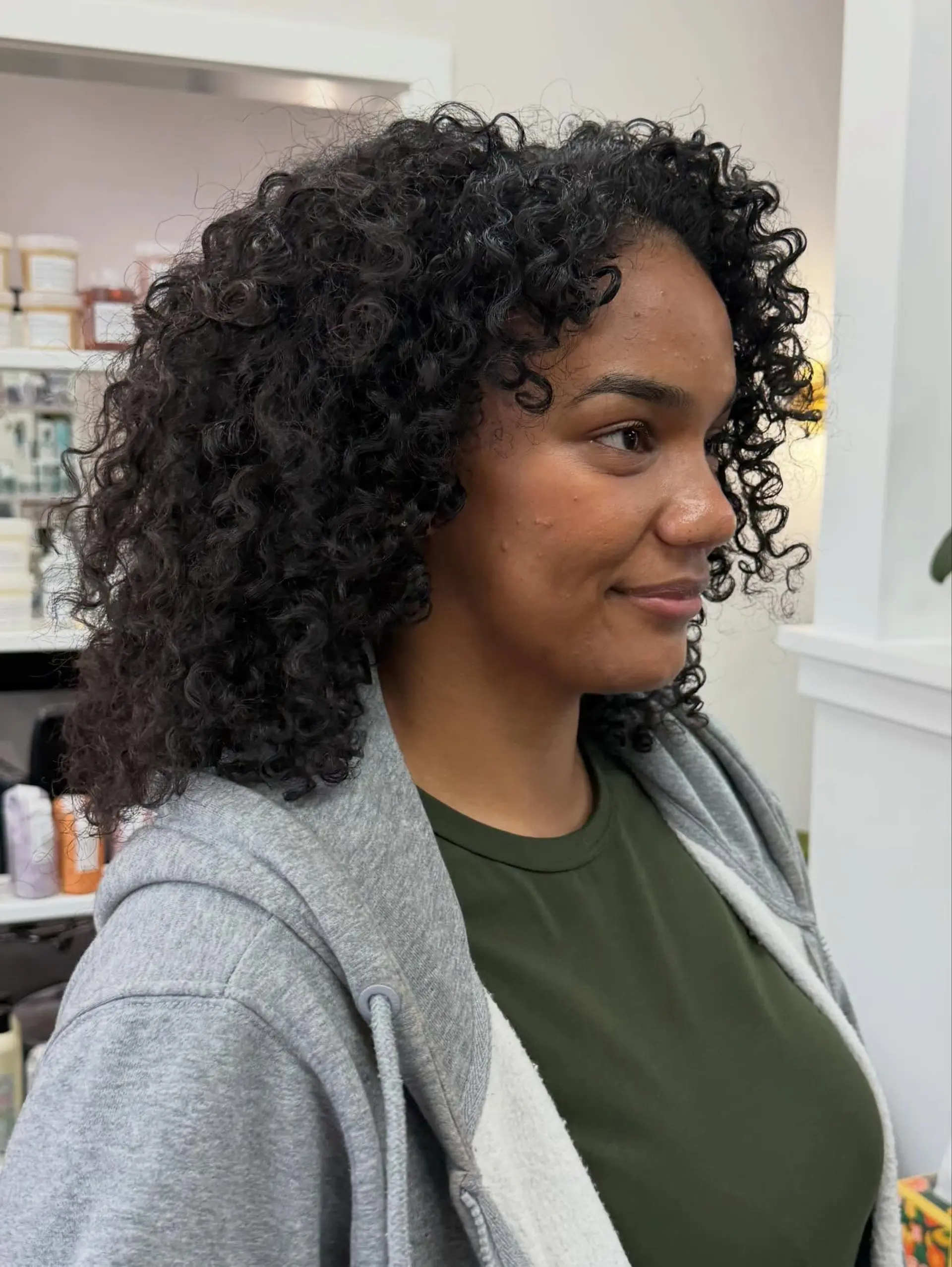 A rounded shoulder-length dry cut featuring hydrated, well-defined natural coils with soft face-framing curl tendrils. 1