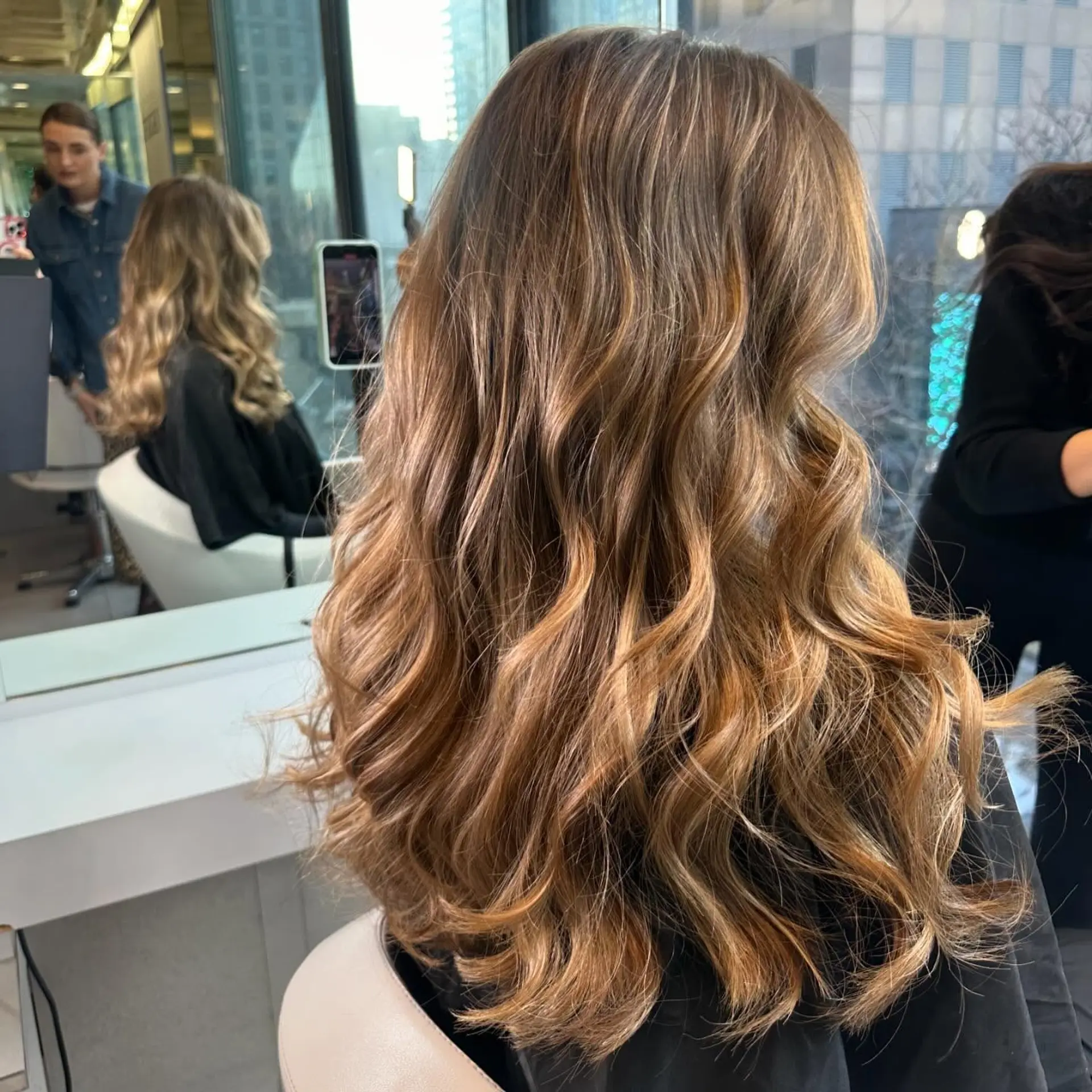 Long dimensional bronde hair styled with soft, cascading loose waves. 1
