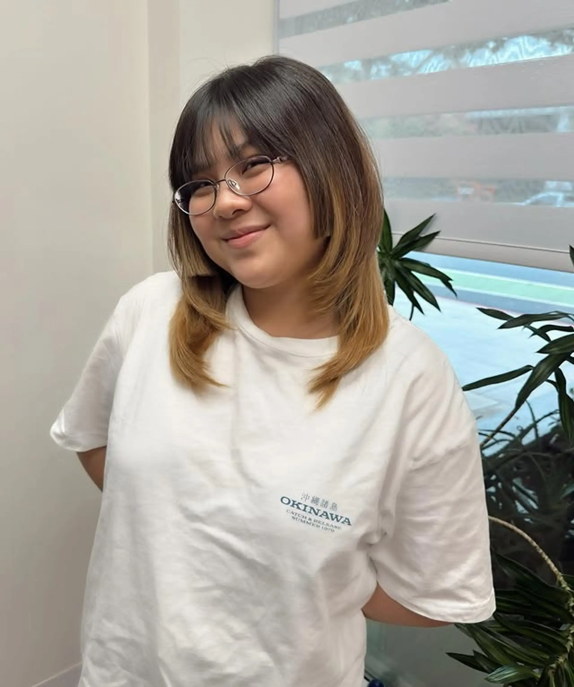 This style features medium-length layered hair with curtain bangs and a brown to blonde ombre. 1