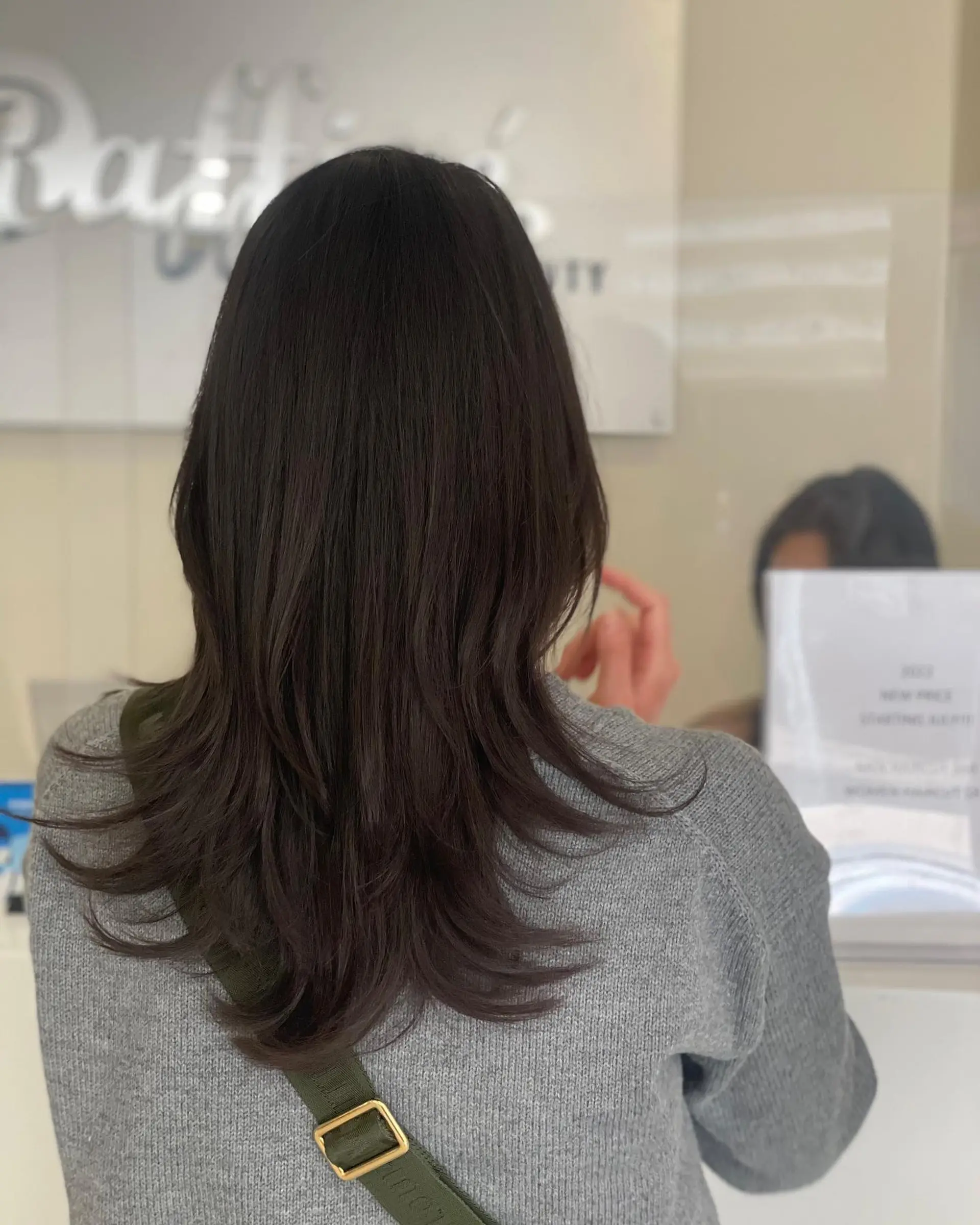 Medium-length dark hair styled in a feathered Korean hush cut with flipped textured ends. 1