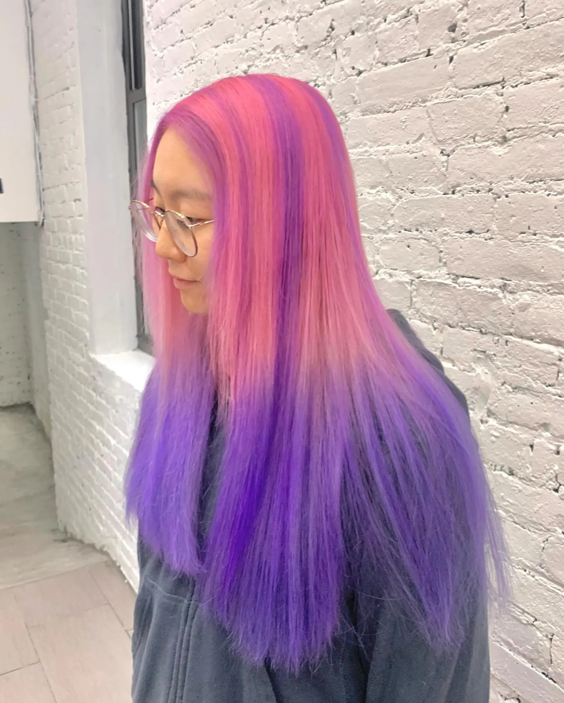 A long, wavy hairstyle featuring an ombre blend of pastel pink, lavender, and purple, characterized by soft waves and vibrant color transitions. 2