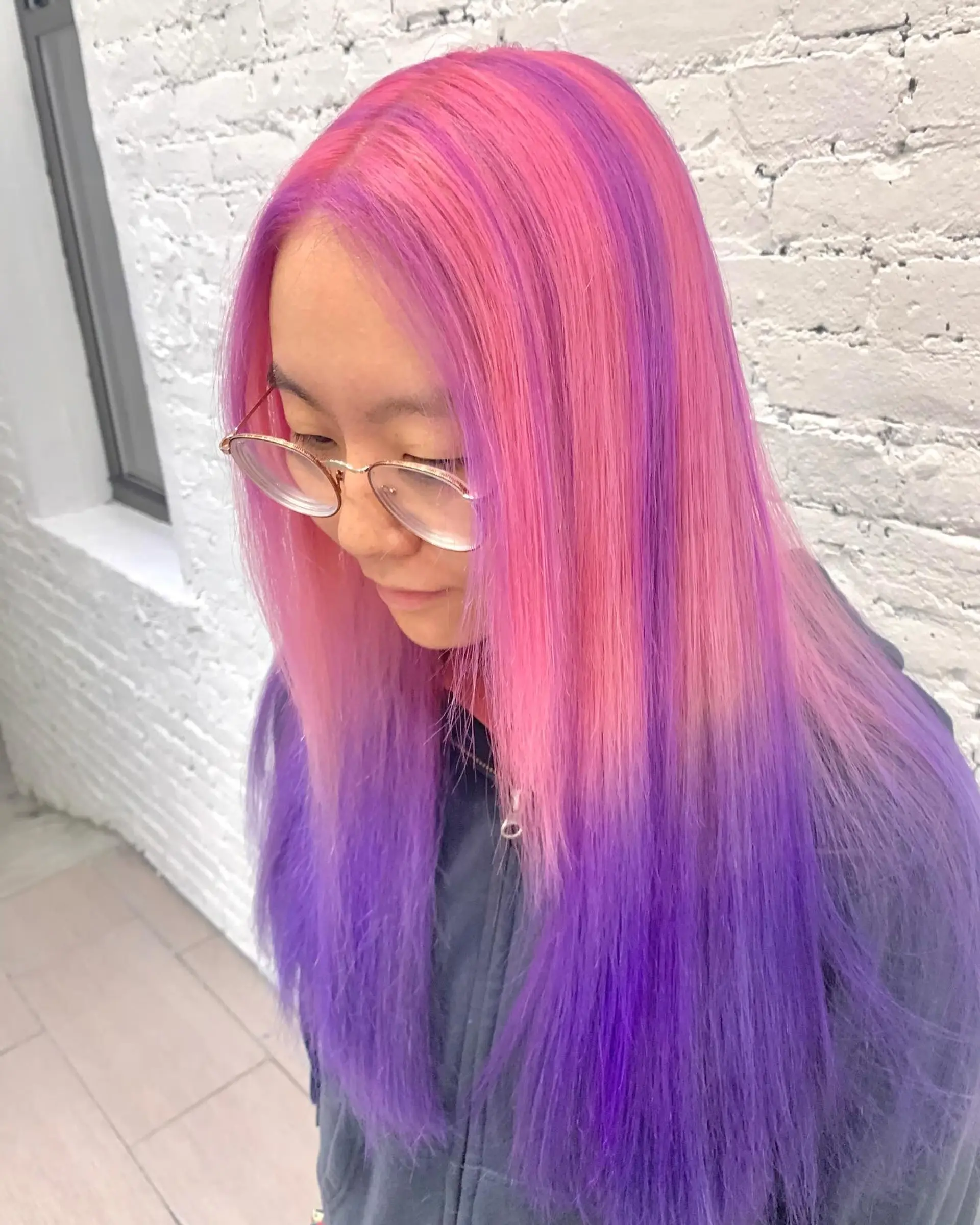 A long, wavy hairstyle featuring an ombre blend of pastel pink, lavender, and purple, characterized by soft waves and vibrant color transitions. 4