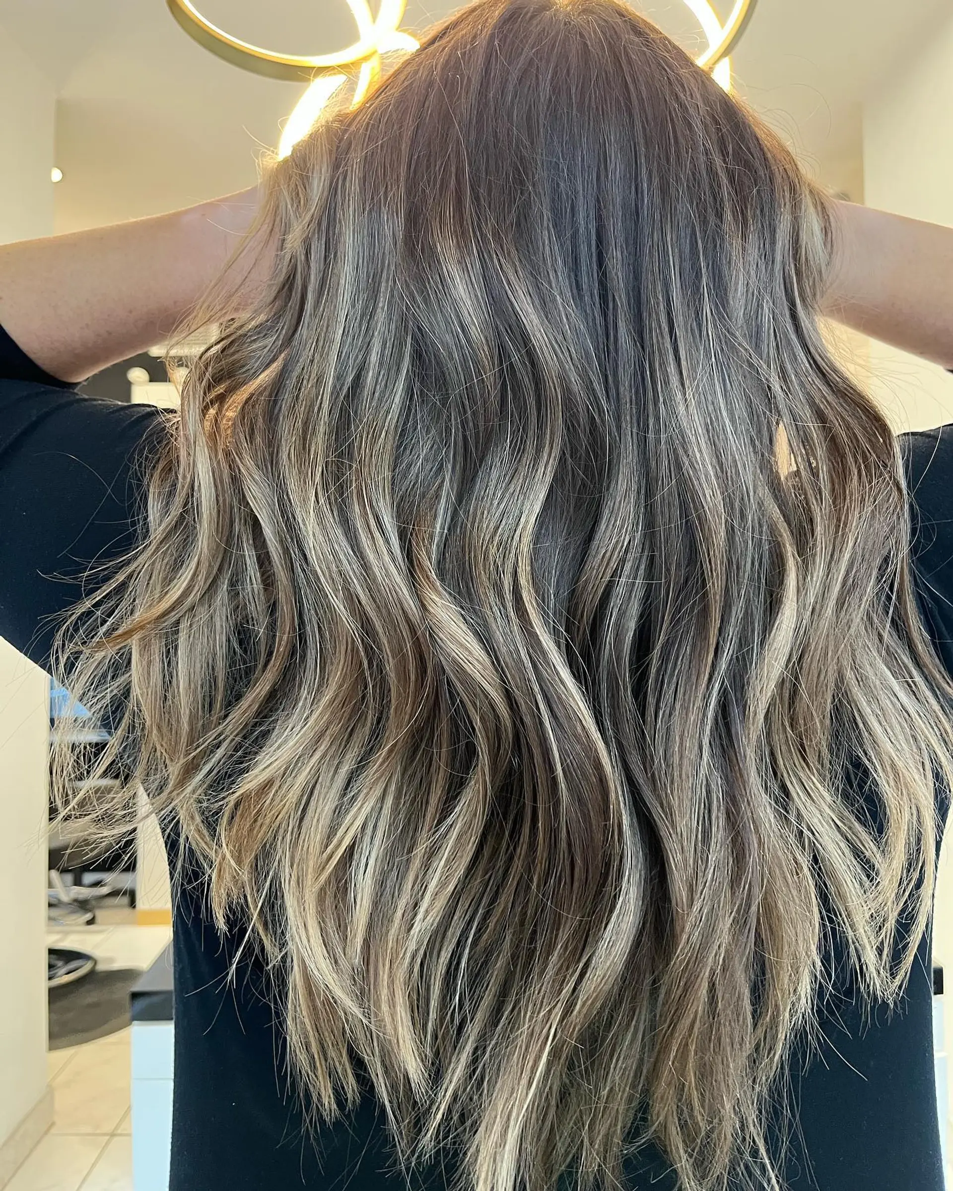A long, wavy hairstyle featuring a bronde balayage. 1