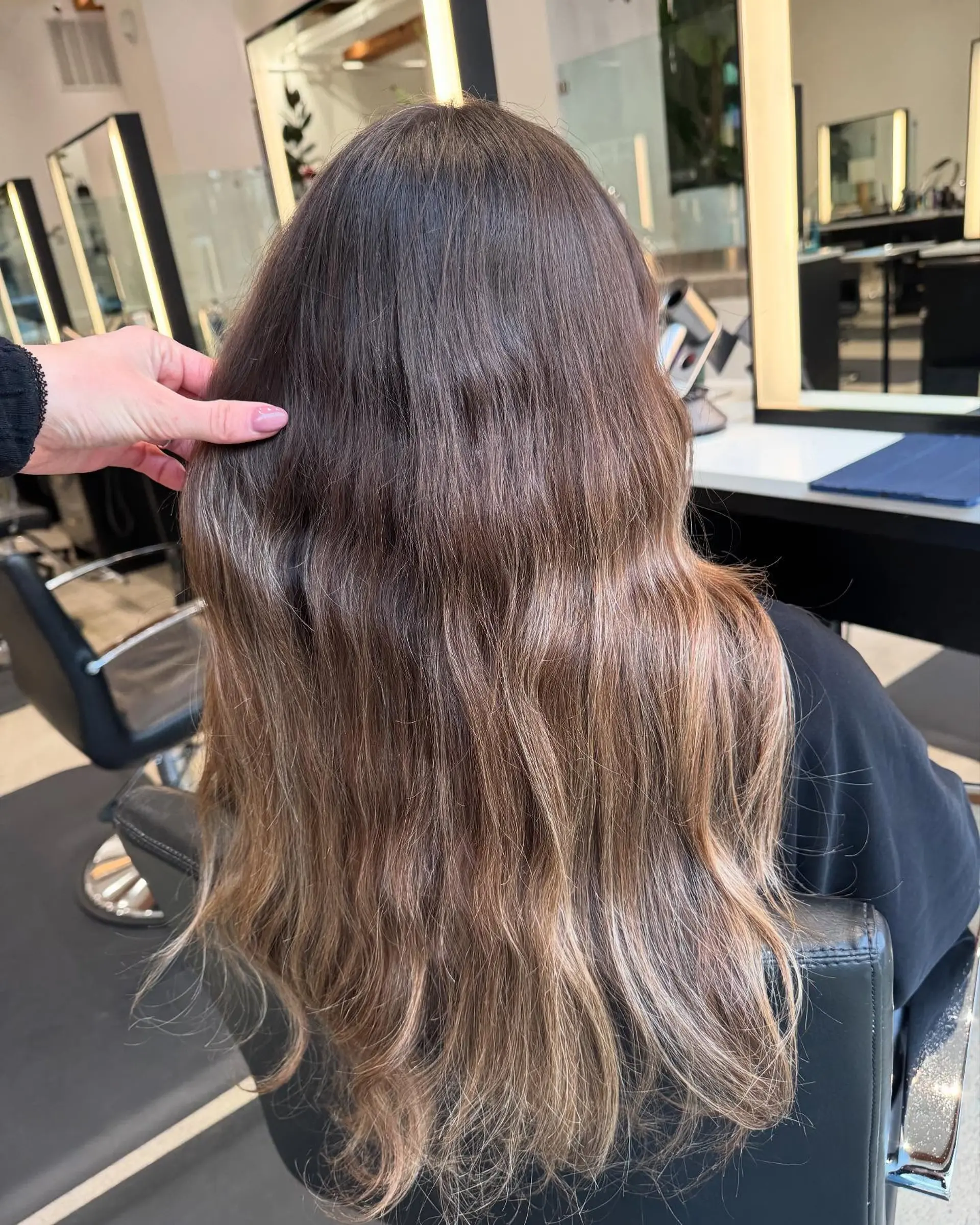 Long, straight hair with a dimensional blonde balayage and subtle waves. 3