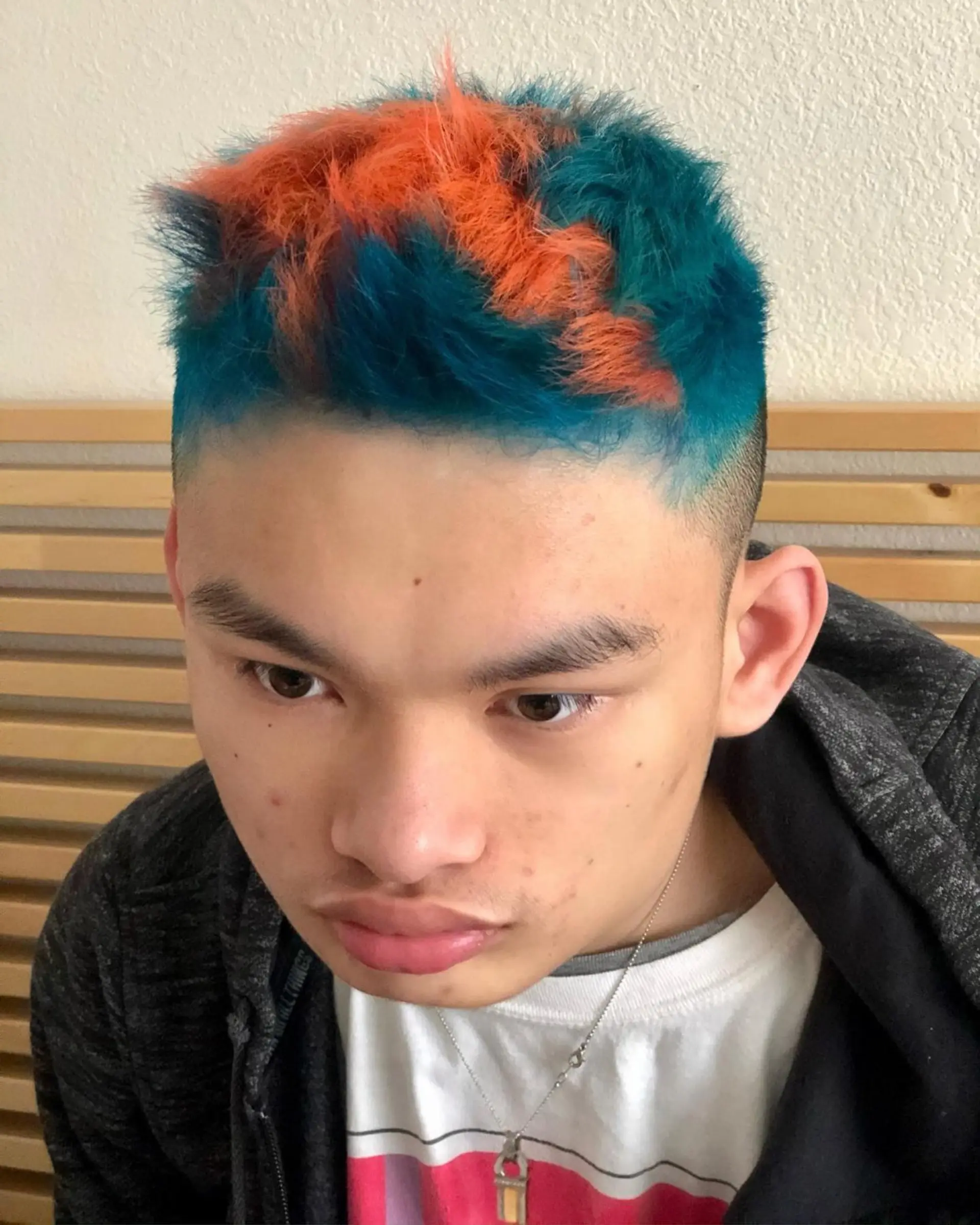 A short, textured cut with faded sides featuring bold, contrasting blocks of vivid teal and vibrant orange. 1