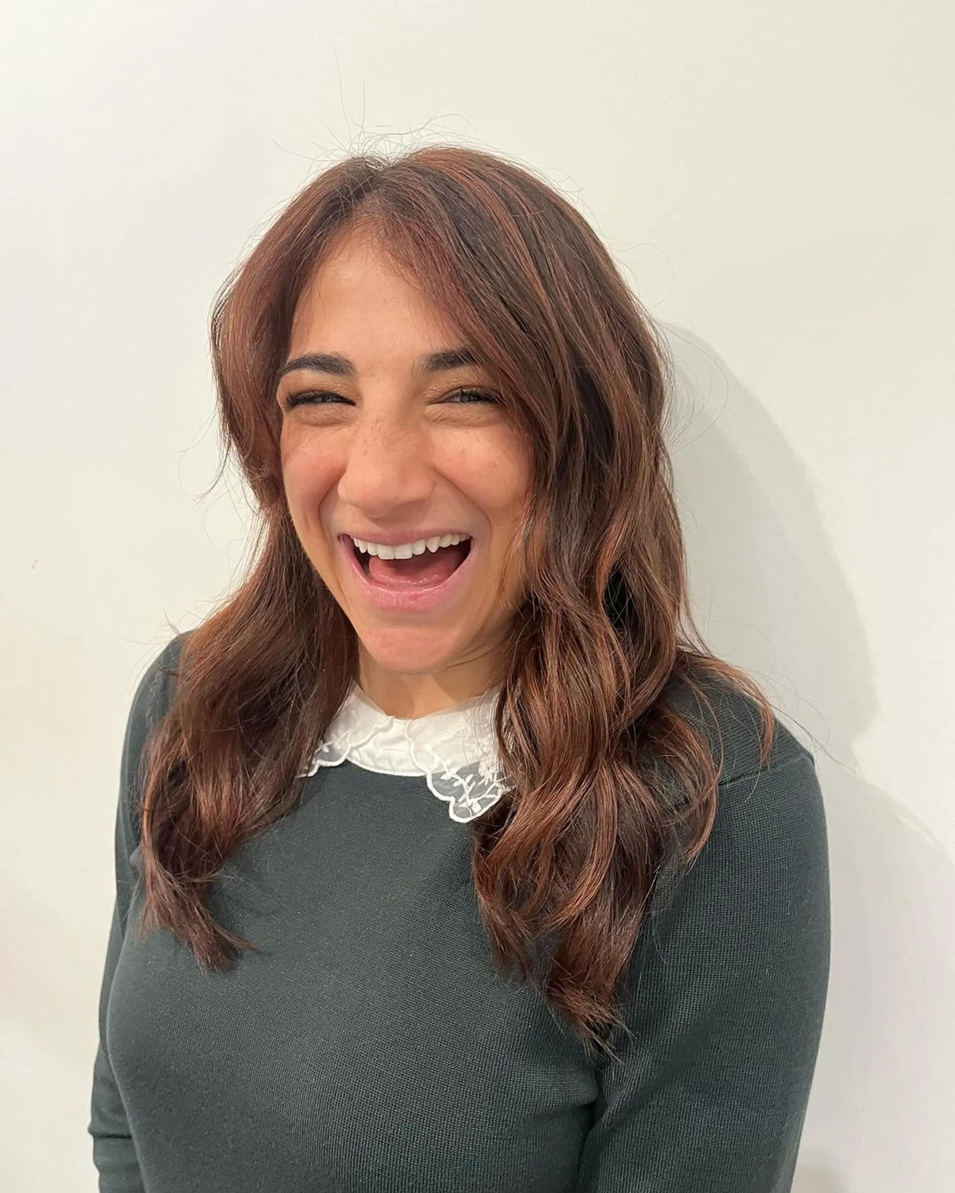 Long, wavy hair with copper and auburn tones, featuring soft waves and a layered cut that adds volume and movement. 2