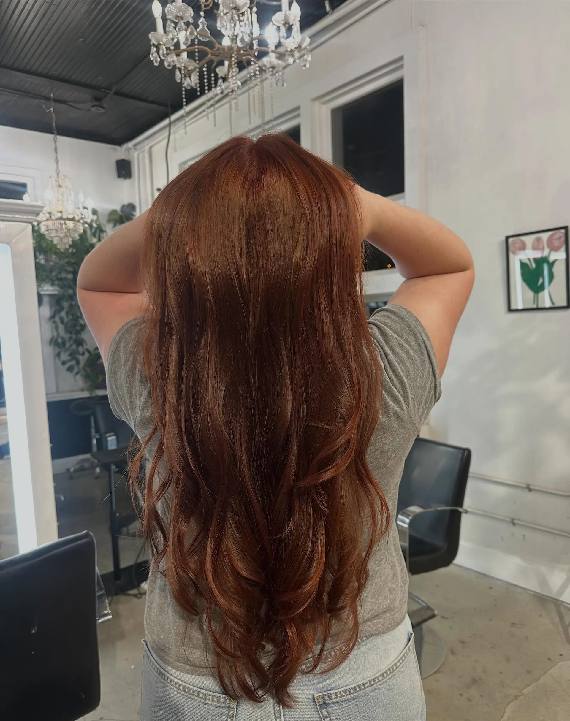 Long rich auburn hair styled with soft, cascading layers and voluminous waves at the ends. 1