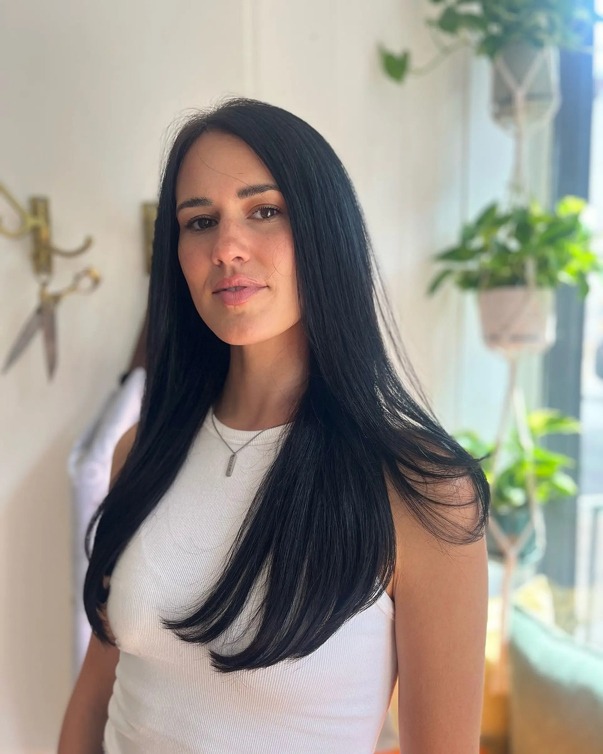 Sleek, straight, and long black hair with a center part and long layers. 1