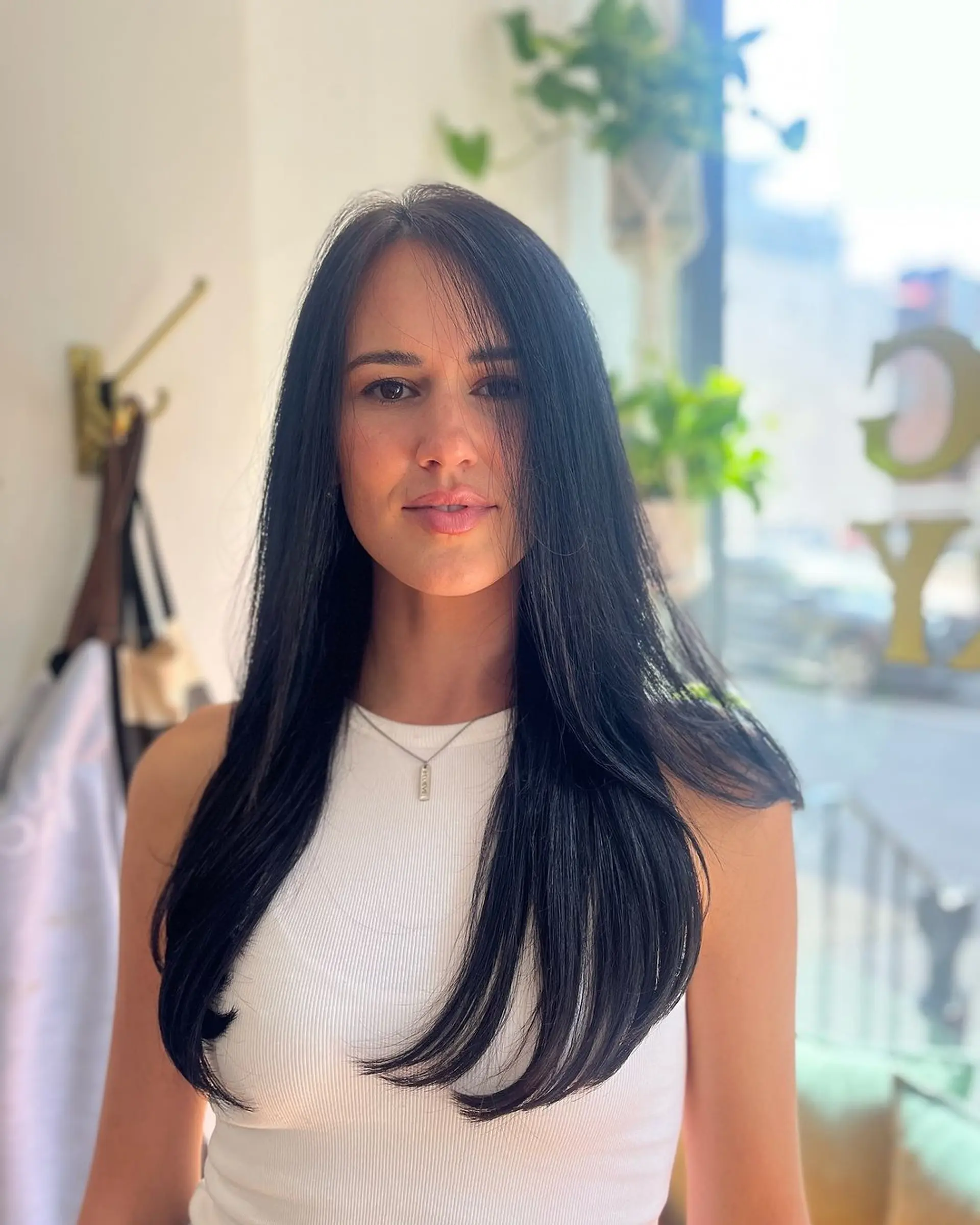 Sleek, straight, and long black hair with a center part and long layers. 2