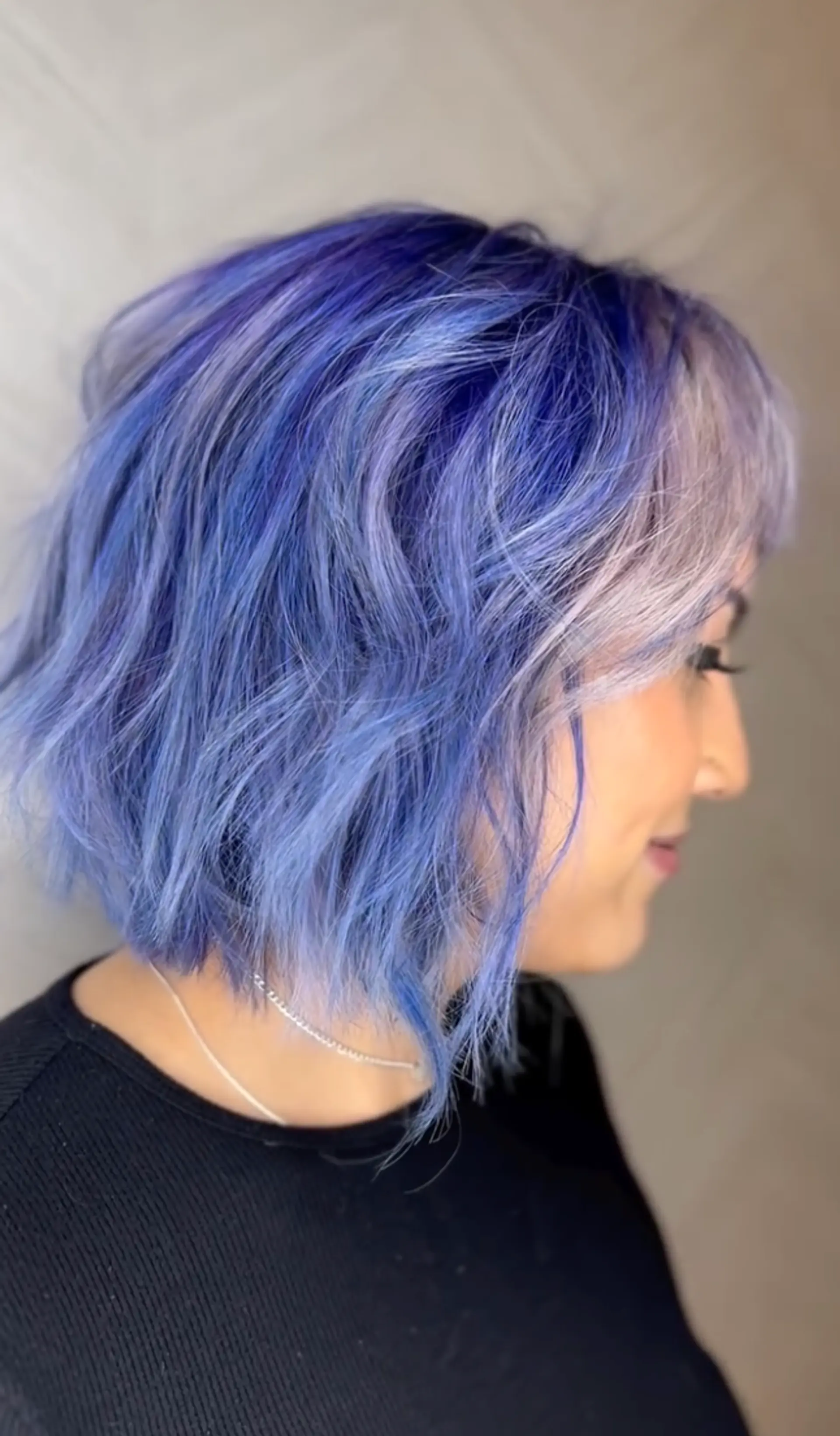 A vibrant and bold wavy bob dyed in shades of blue, lavender, and silver. Layers and a side part add texture and volume to the short cut.

Color by @simabeautynyc
Cut and style by @juliamannino_hair
 1