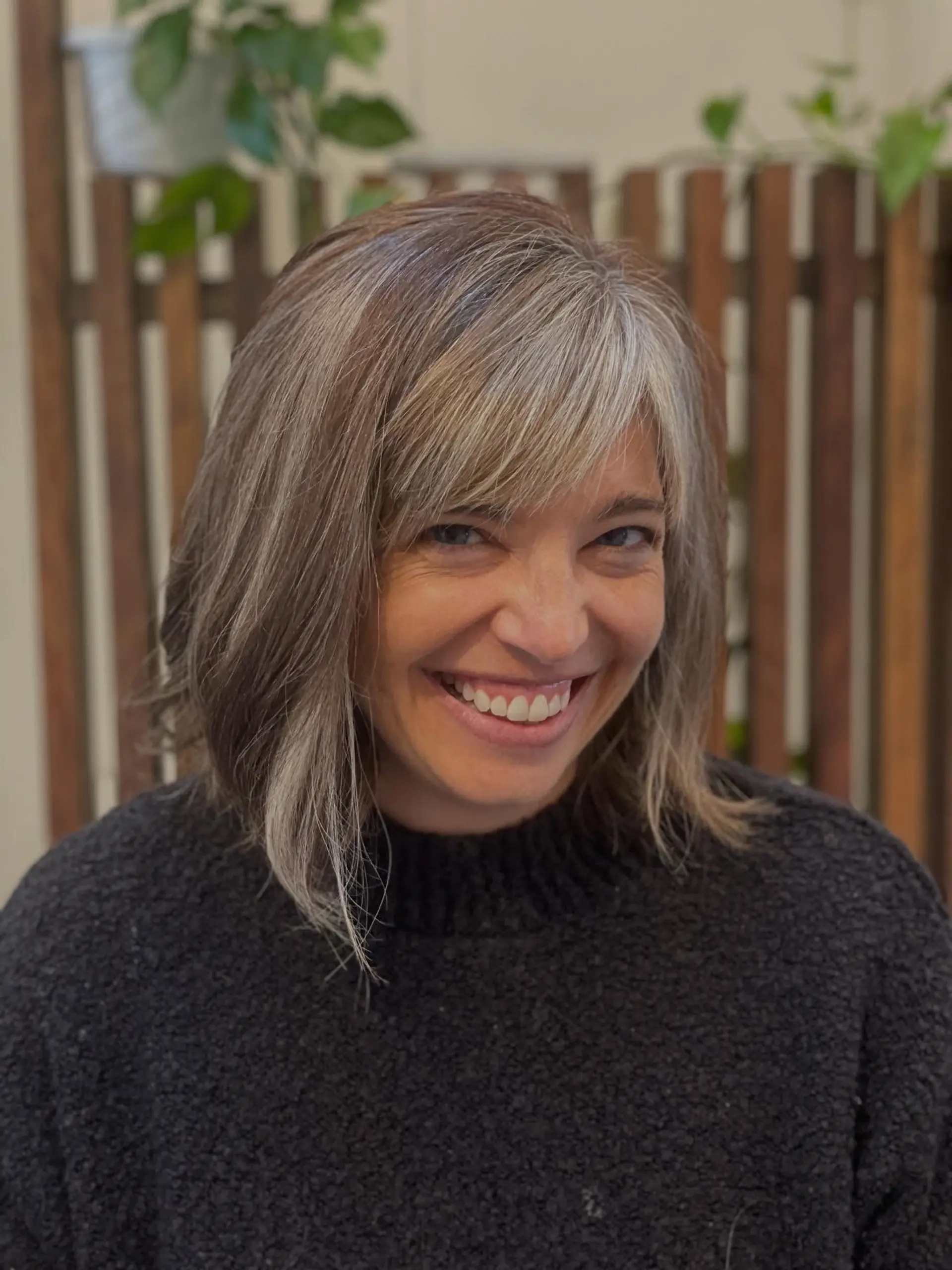A textured bob with side-swept bangs featuring natural silver blended with soft hazelnut dimensional ribbons. 1