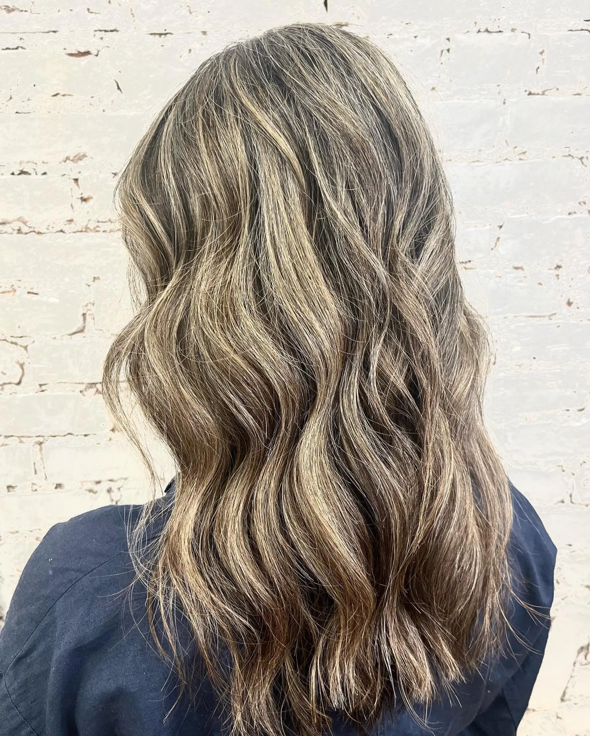 Long hair featuring seamless dimensional foilyage highlights and lowlights styled in soft, loose waves. 1