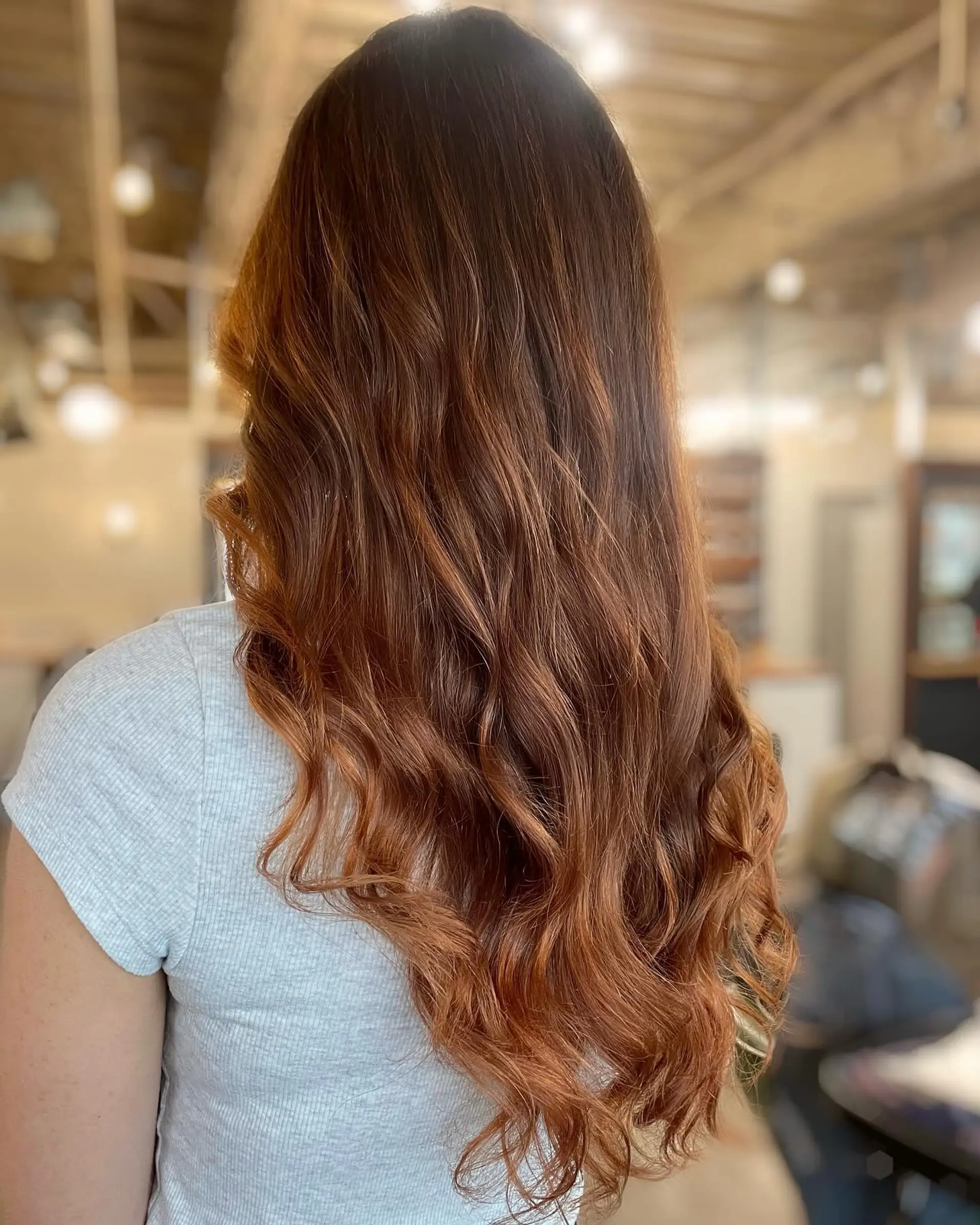 Long cascading copper balayage finished with soft, loose waves. 1