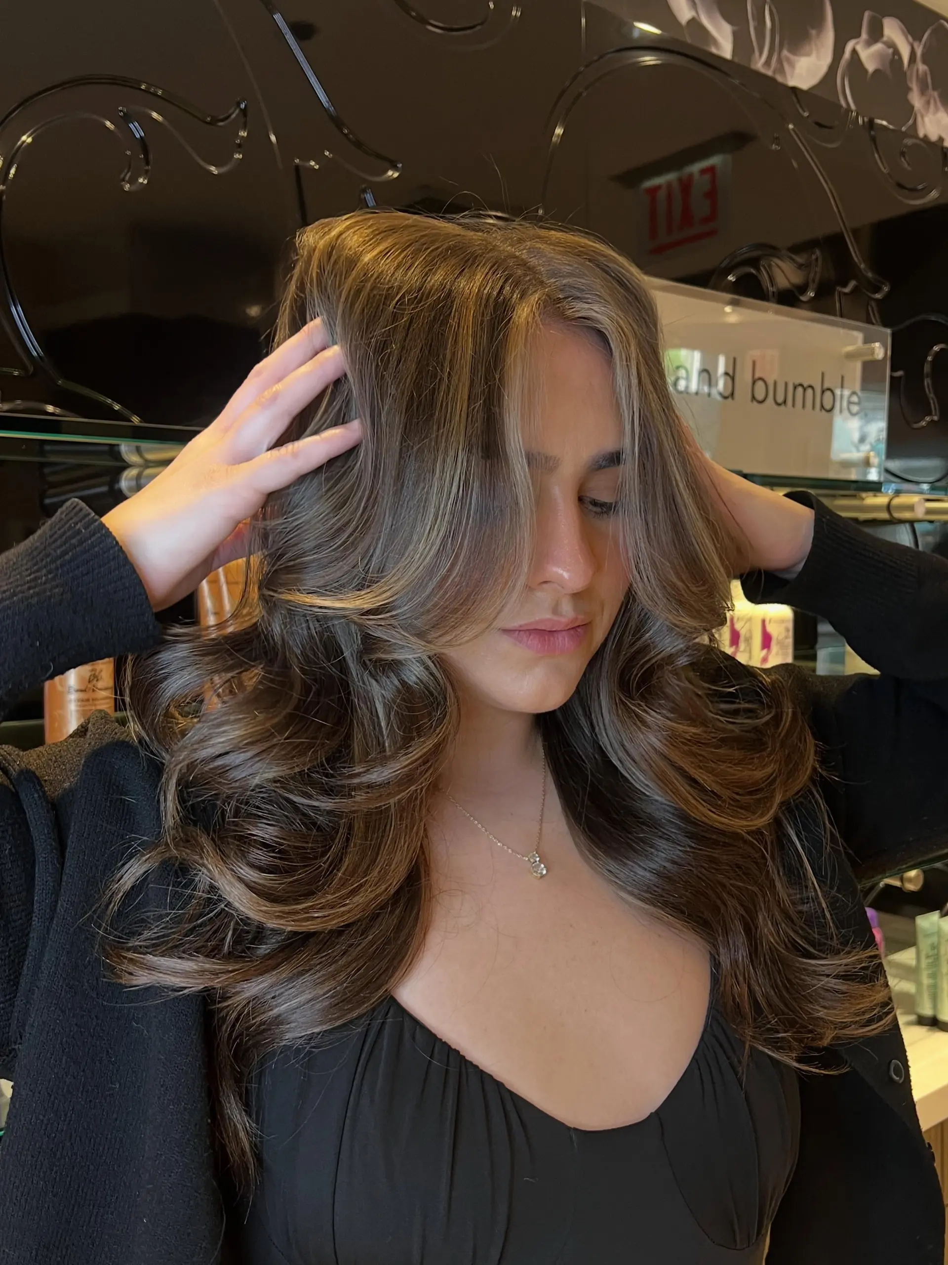Long dimensional brunette hair styled in a bouncy blowout with layered face-framing waves. 1