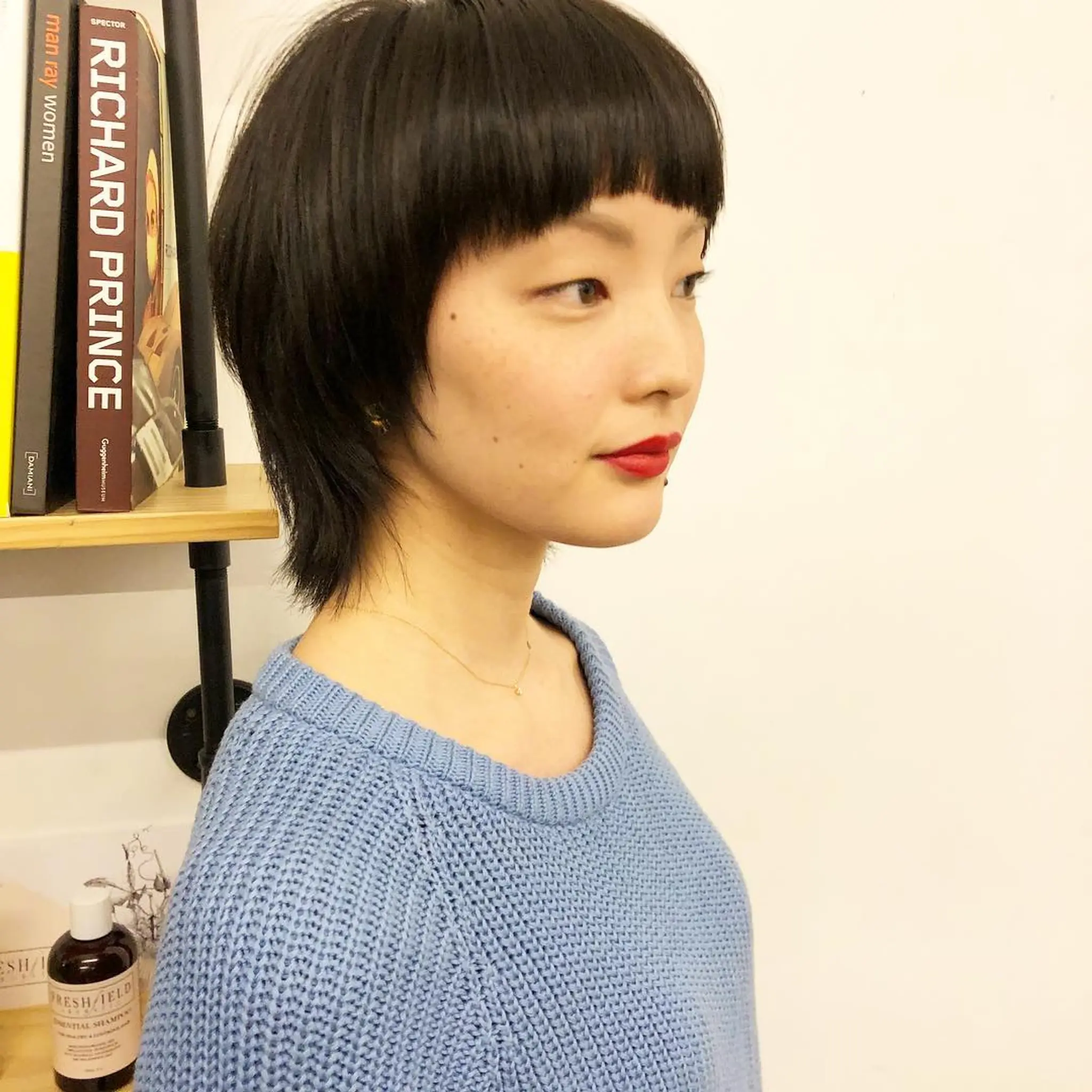 A unique blend of blunt bangs with a layered, neck-length bob featuring a sleek finish.