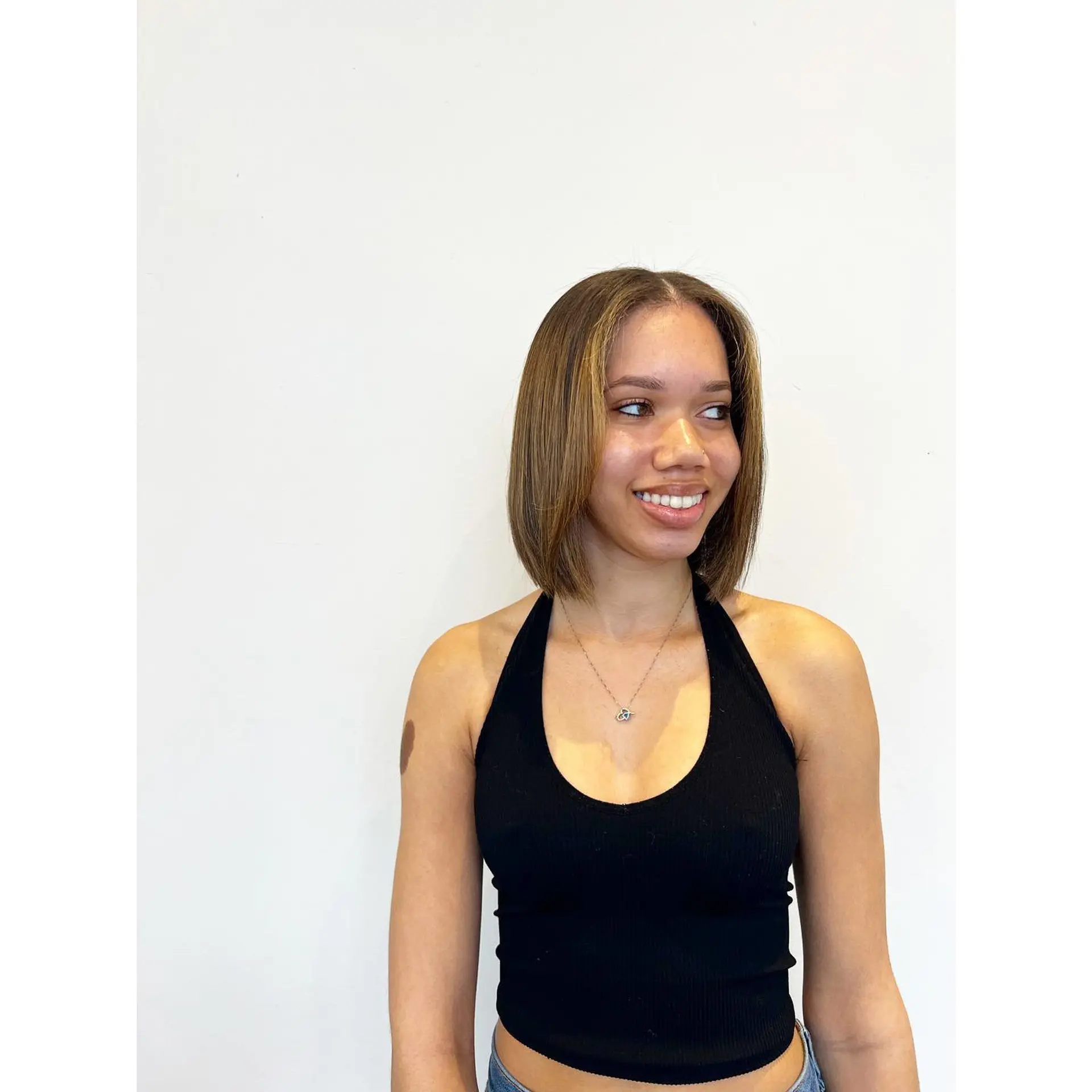 A sleek, shoulder-grazing blunt bob styled straight with a middle part and subtle face-framing highlights. 1