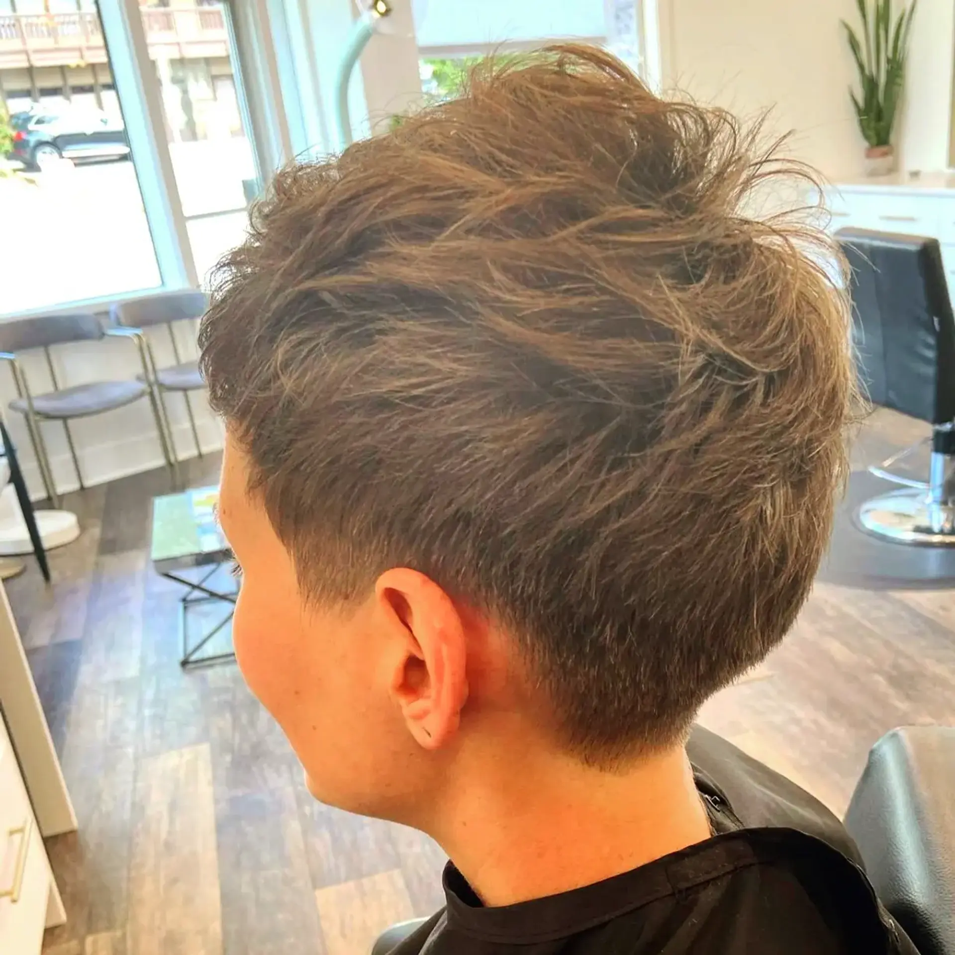 A textured short pixie cut with a clean, tapered nape and soft, piecey layers through the crown. 1