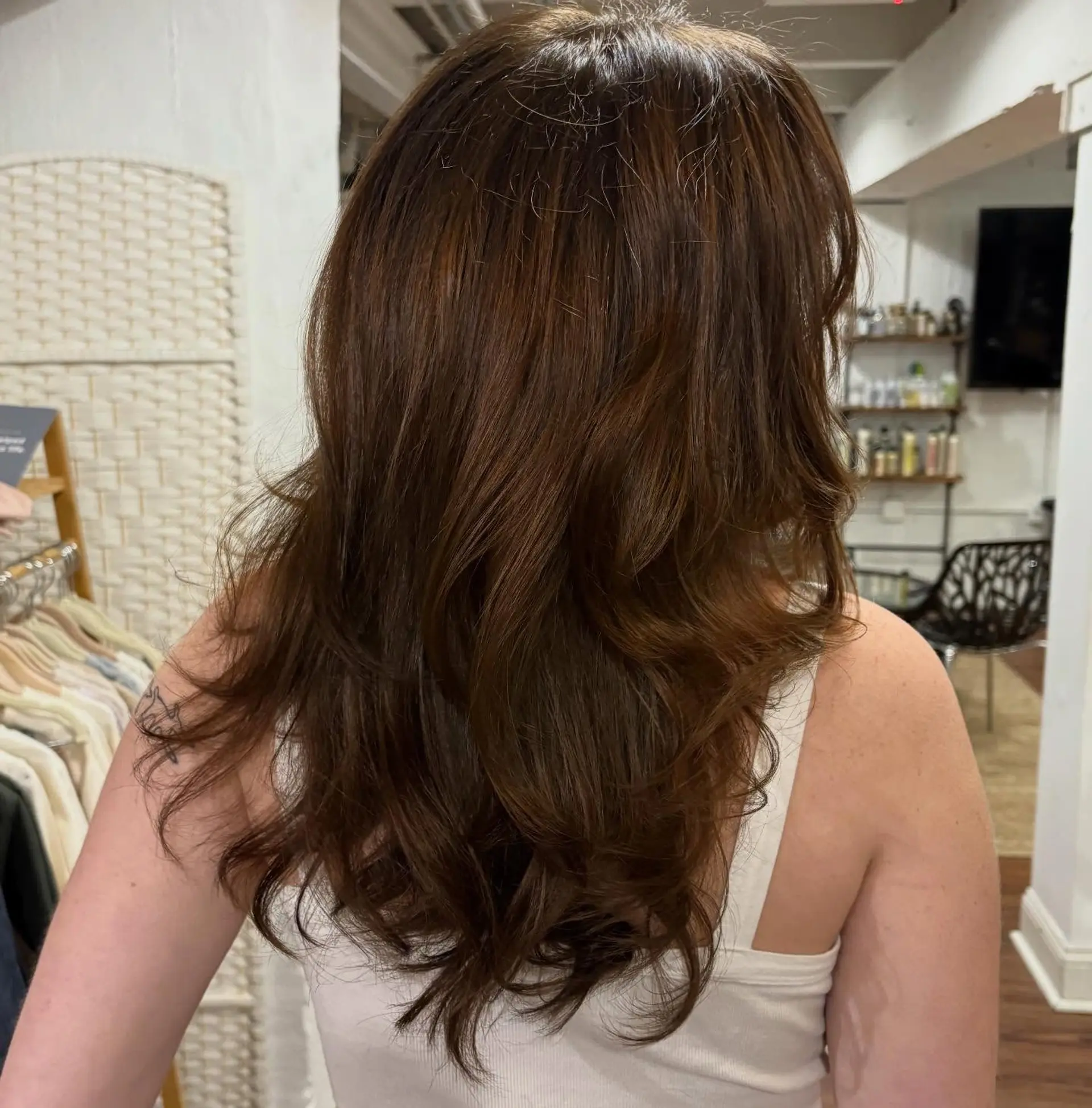 Long chocolate brunette hair cut in cascading layers and styled into a voluminous, soft-waved blowout. 1