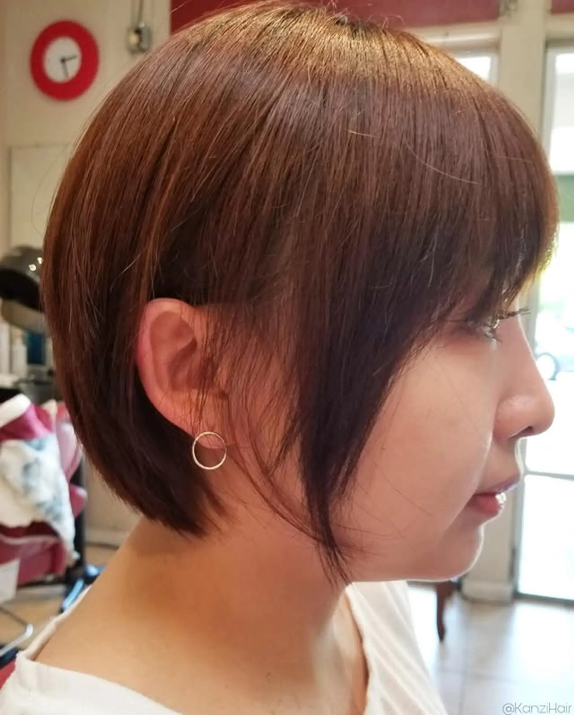 A chic, short layered bob with sleek, straight hair and soft, face-framing side-swept bangs. 1