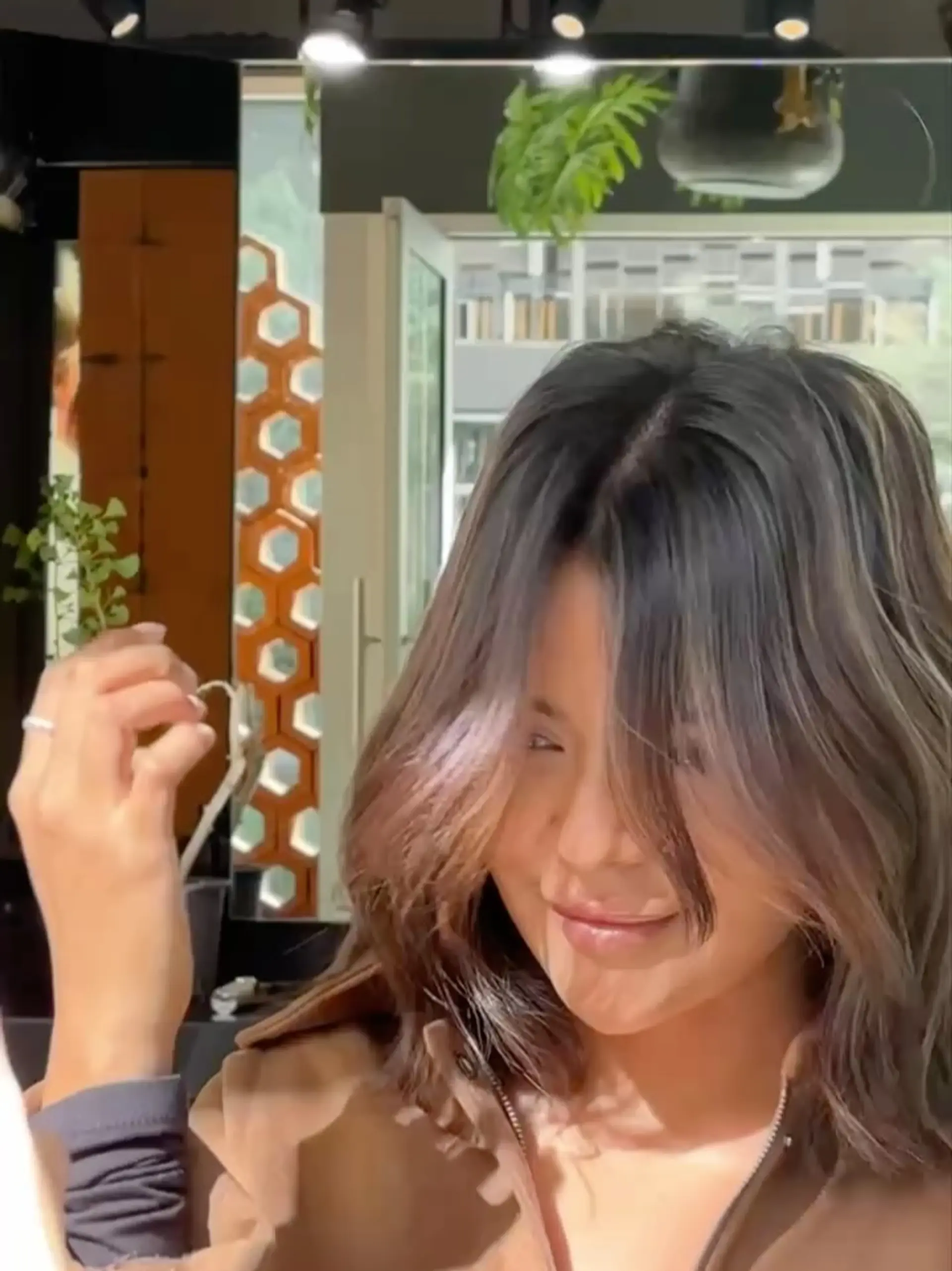 A medium-length textured lob styled with soft, tousled waves and parted curtain bangs framing the face. 1
