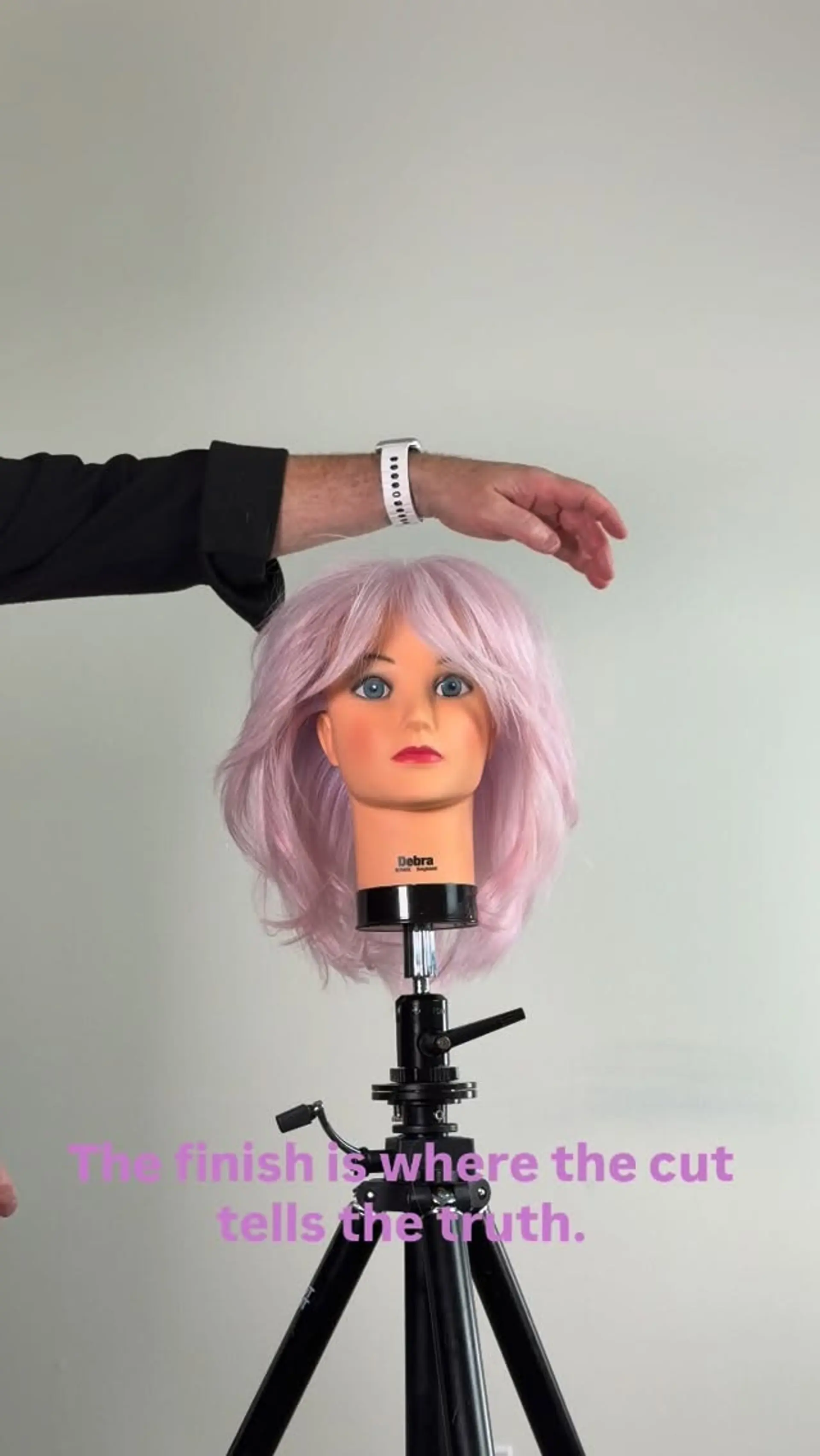 A textured shoulder-length lob featuring soft, feathered layers and parted curtain bangs in a light pastel pink tone. 1