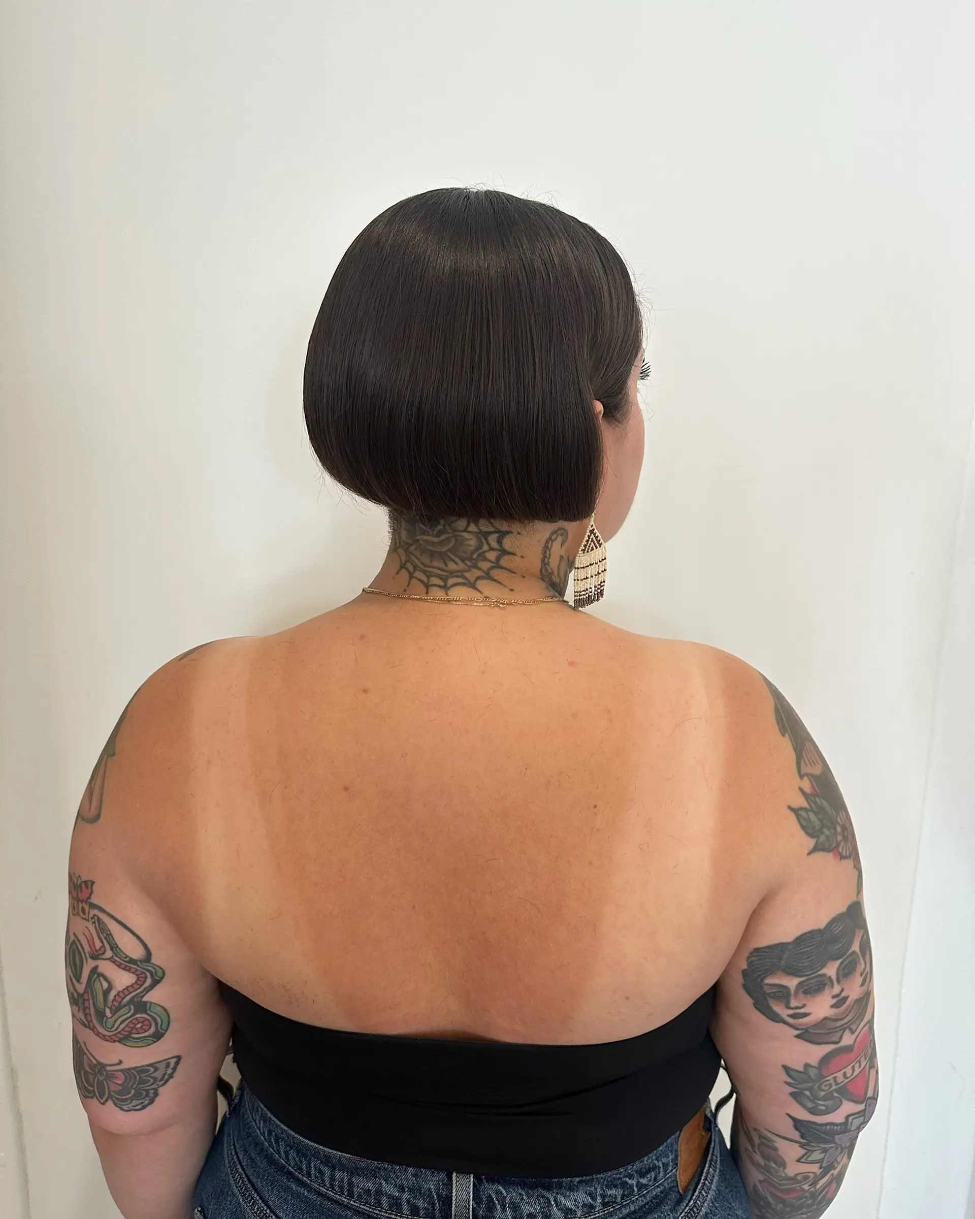 A sleek, precision-cut blunt bob sitting above the neck hairline with a smooth, rounded finish. 1