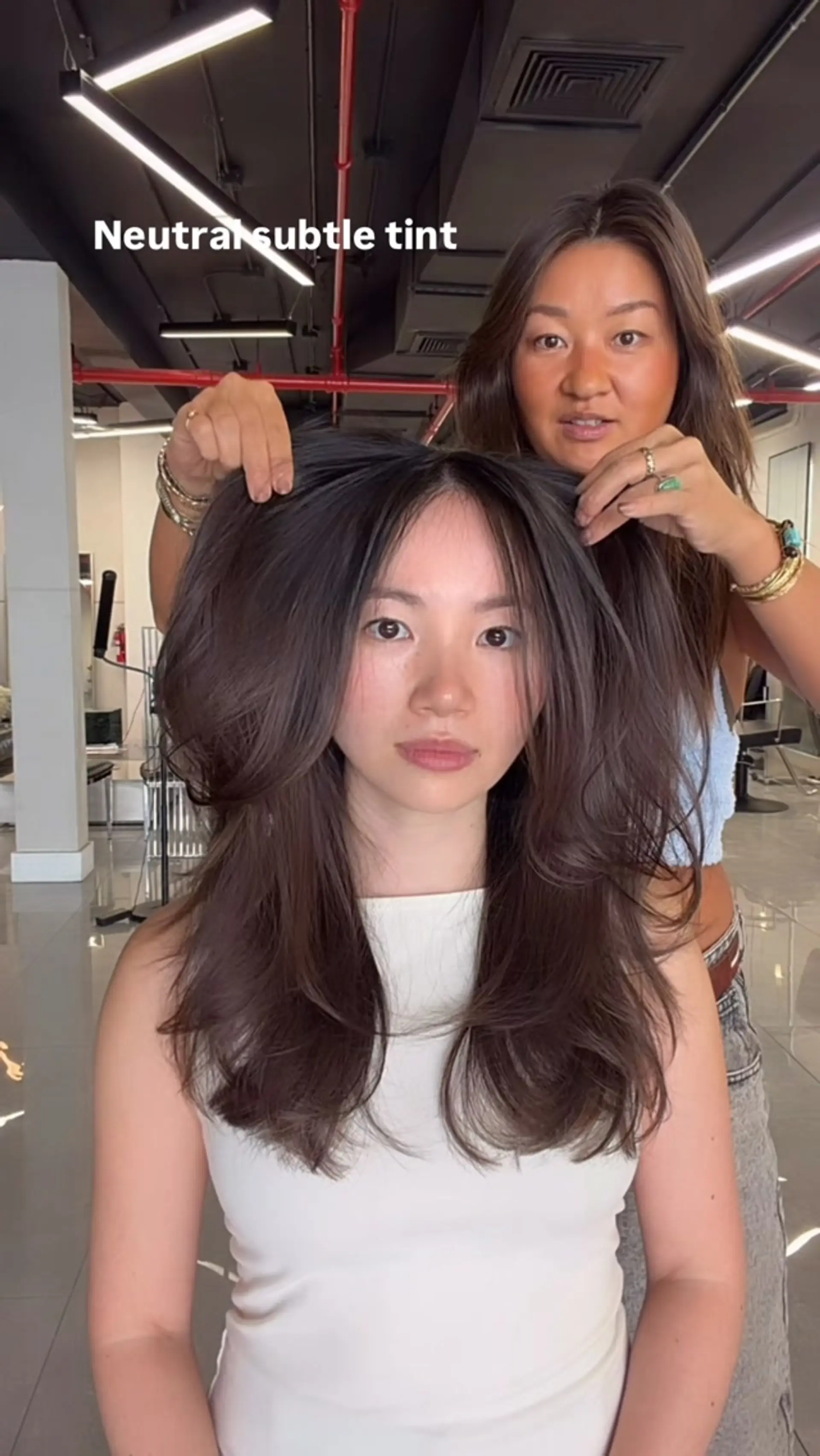 Long layered haircut with face-framing pieces and curtain bangs, styled in a full, voluminous blowout. 1