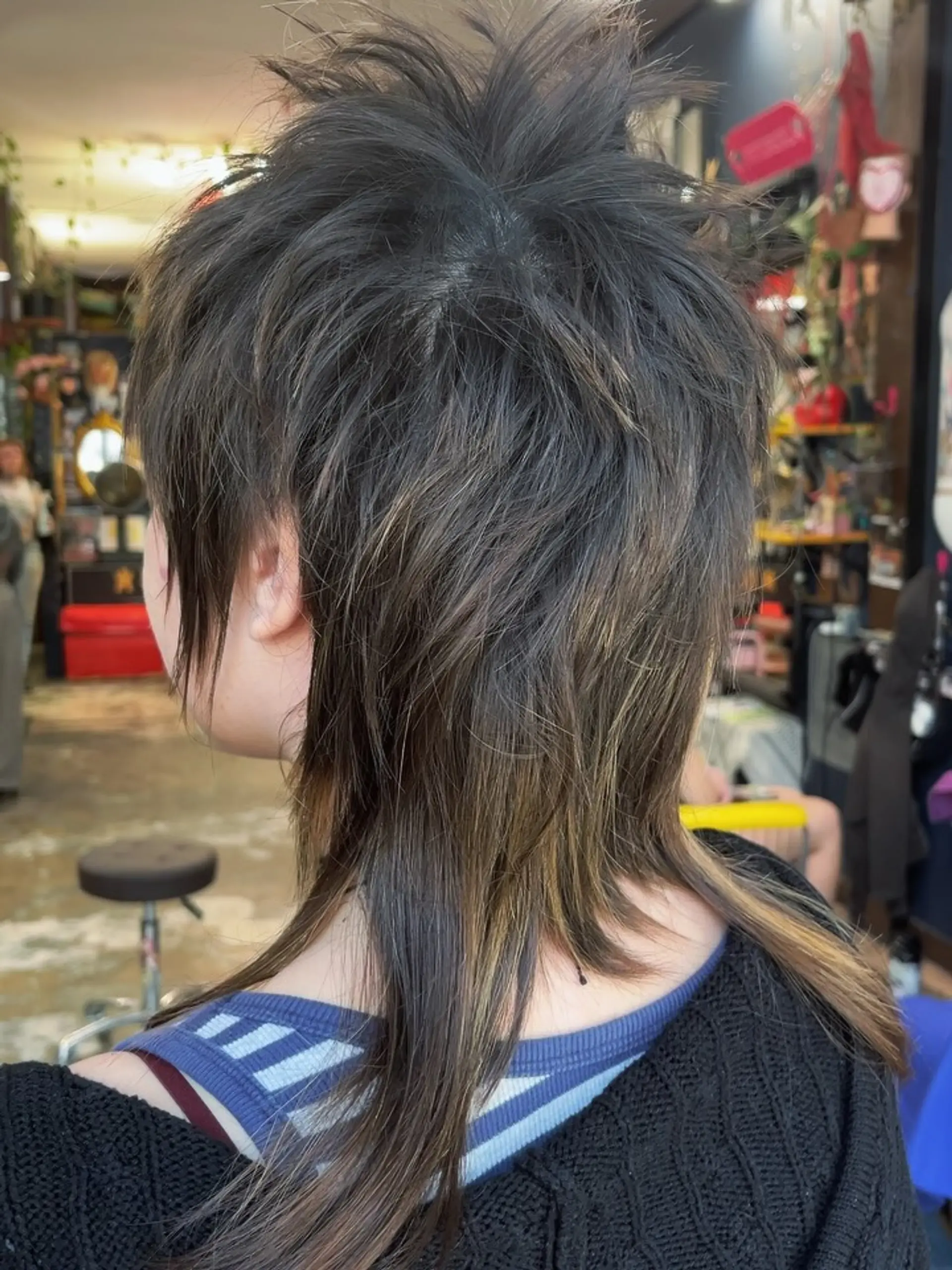 A choppy, heavily textured shag mullet with short spiky crown layers, face-framing strands, and piecey length at the back. 1