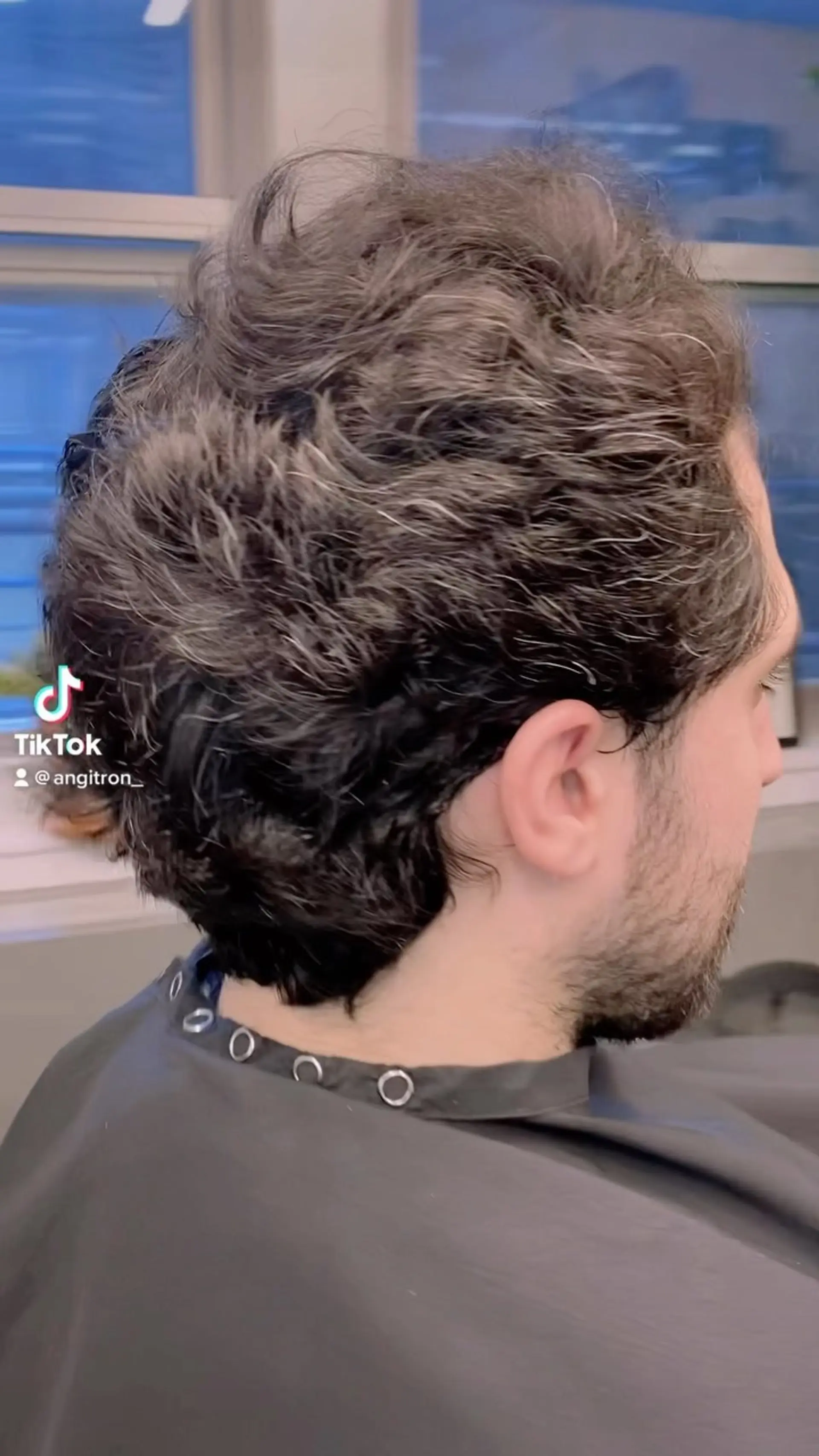 A textured scissor-over-comb haircut on naturally wavy, salt-and-pepper hair. 1