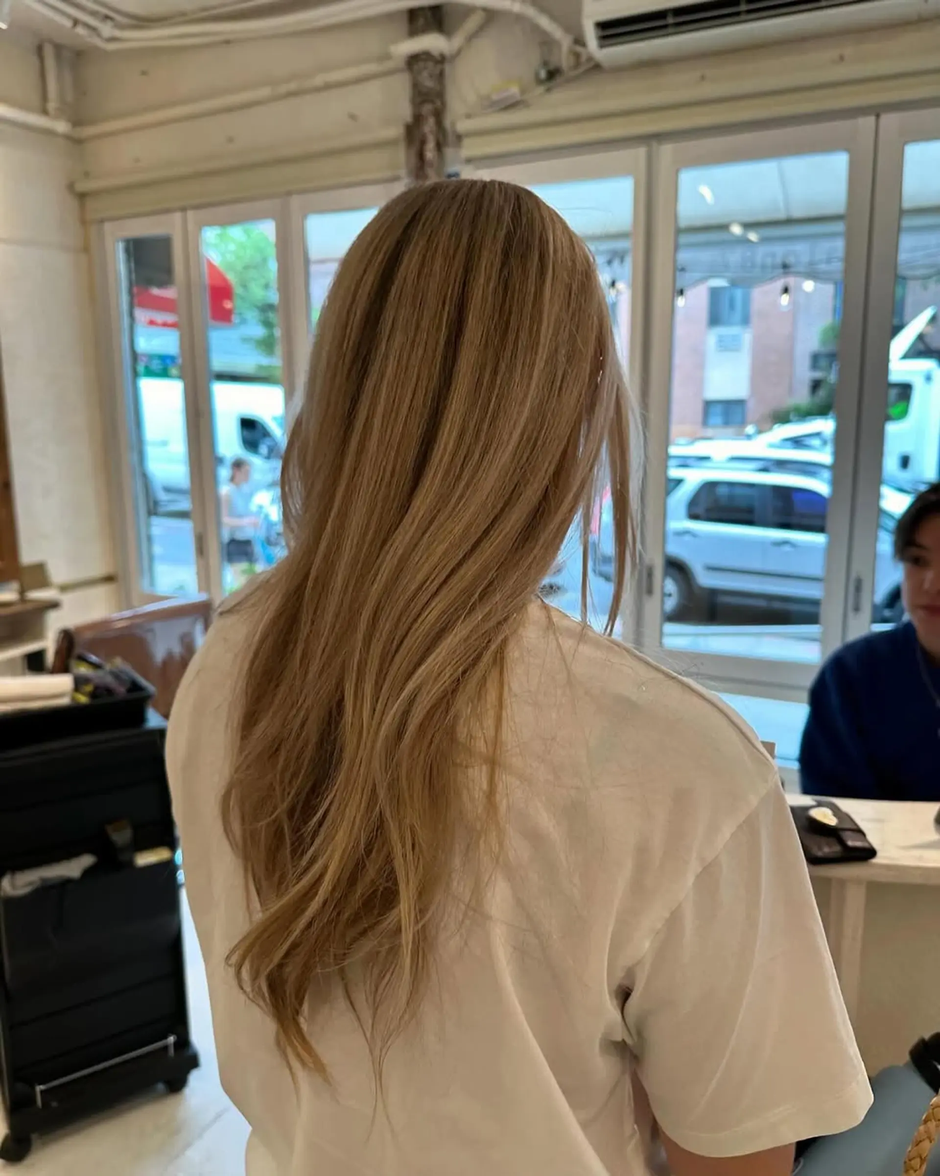 Long, wavy, blonde hair with side-swept bangs and layered waves, featuring natural volume and a beachy texture. 3