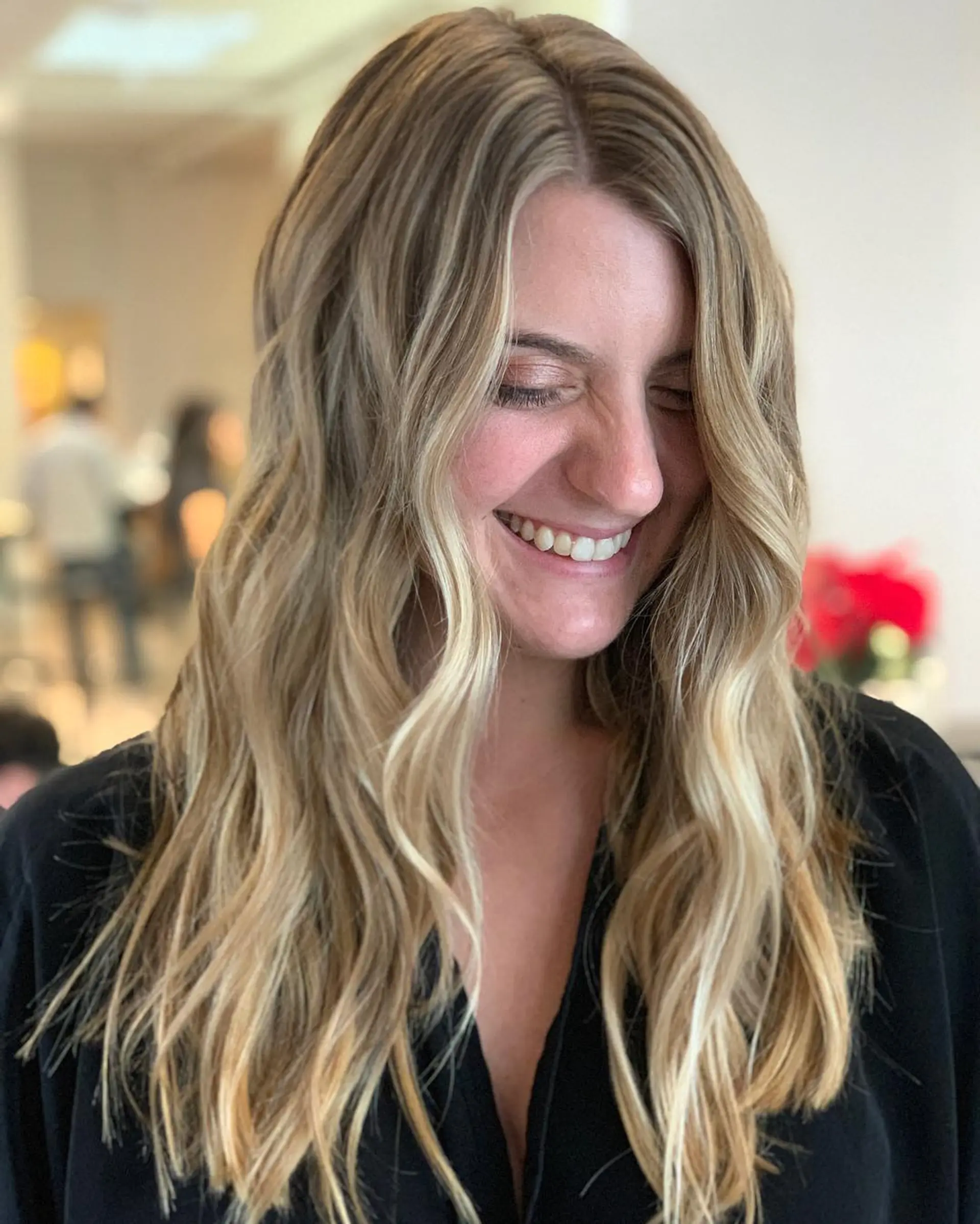 Long dimensional blonde hair with fine babylights styled into soft, beachy waves. 1