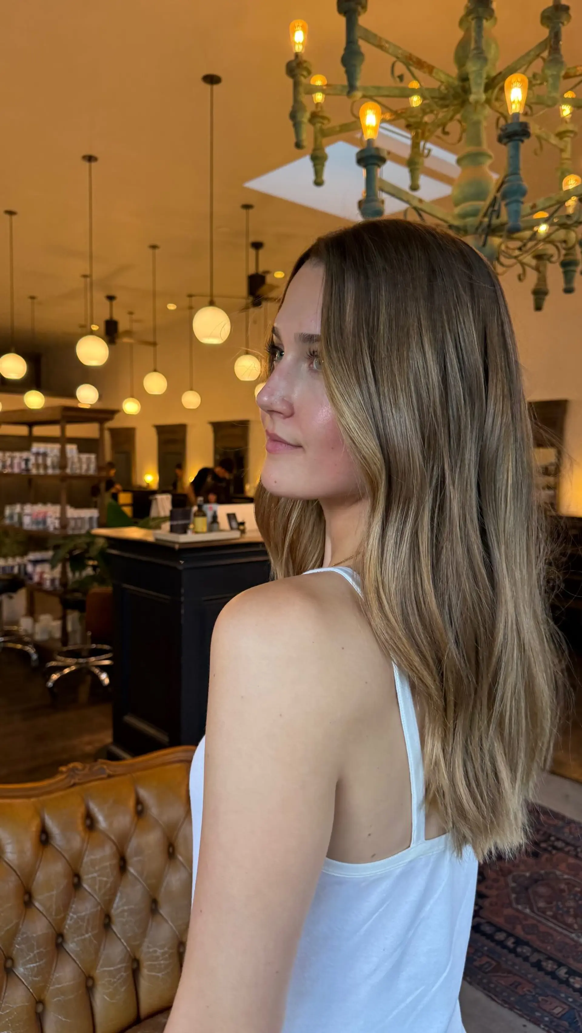 Long, soft natural blowout with seamless blended balayage highlights throughout medium brown hair. 1