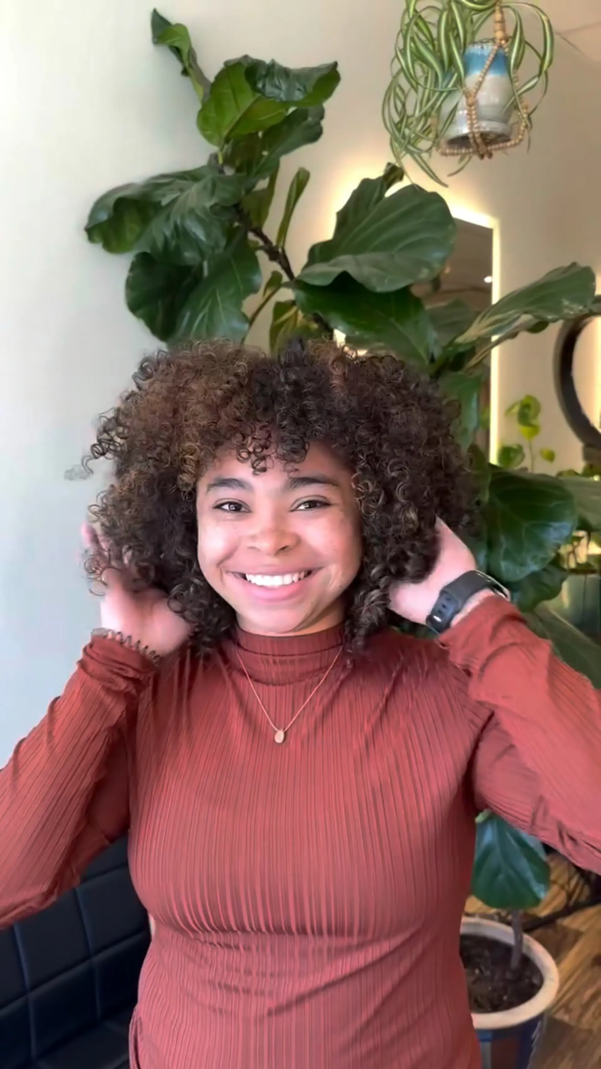 Voluminous, shoulder-length defined curls featuring a rounded layered silhouette and textured curly bangs. 1