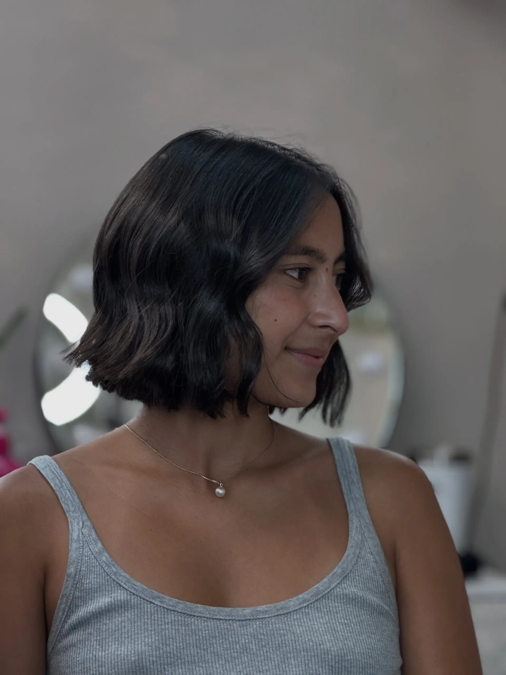 A chin-length blunt bob styled with effortless, soft waves. 1