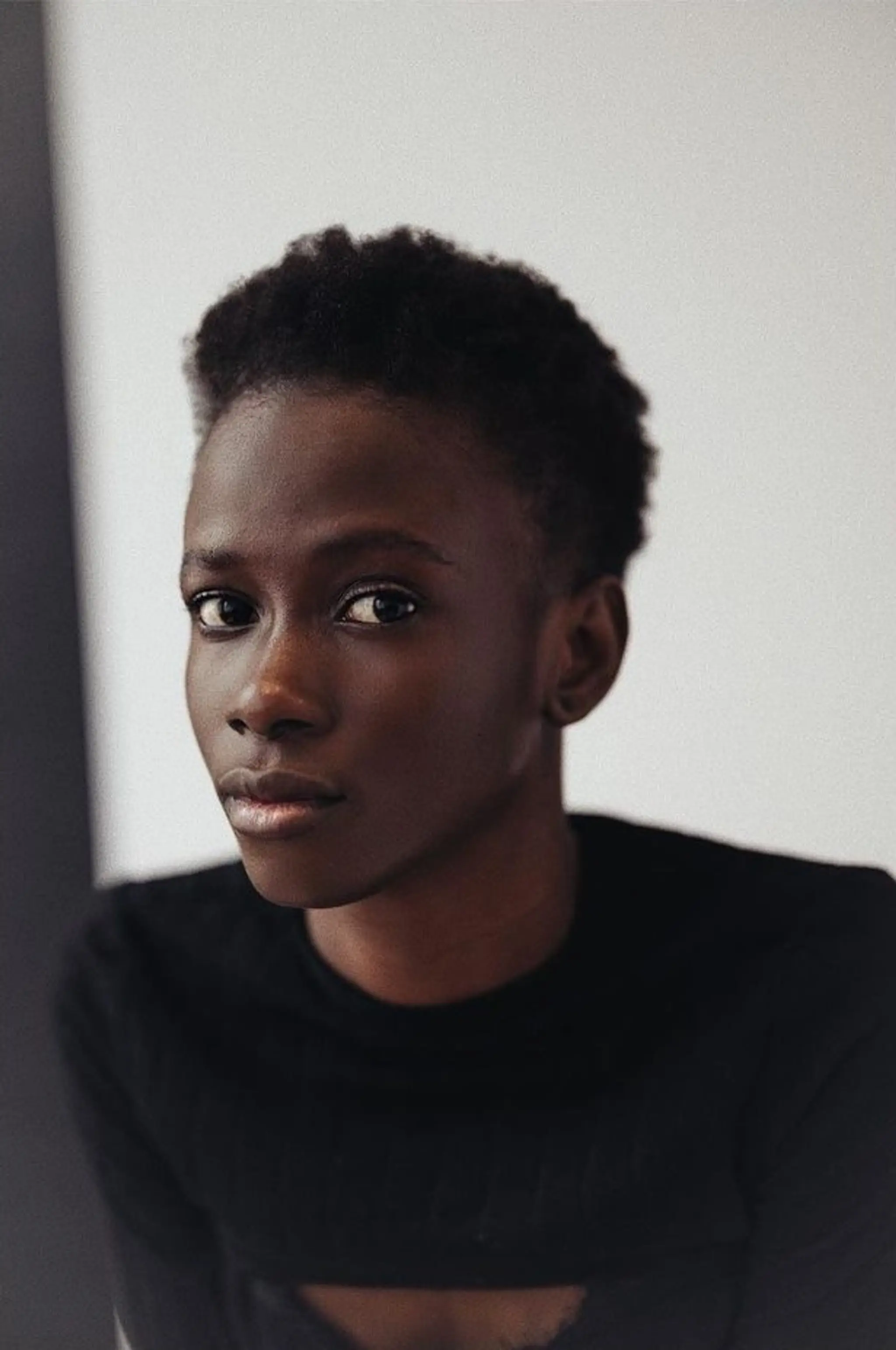 A short afro with tapered sides, featuring natural curly texture and a minimalistic, clean look. Oyindi ✨⁣⁣
Haircut: @sdr______
📸: @yay___studio
Agency: @skorpionmgmt
⁣⁣ 2