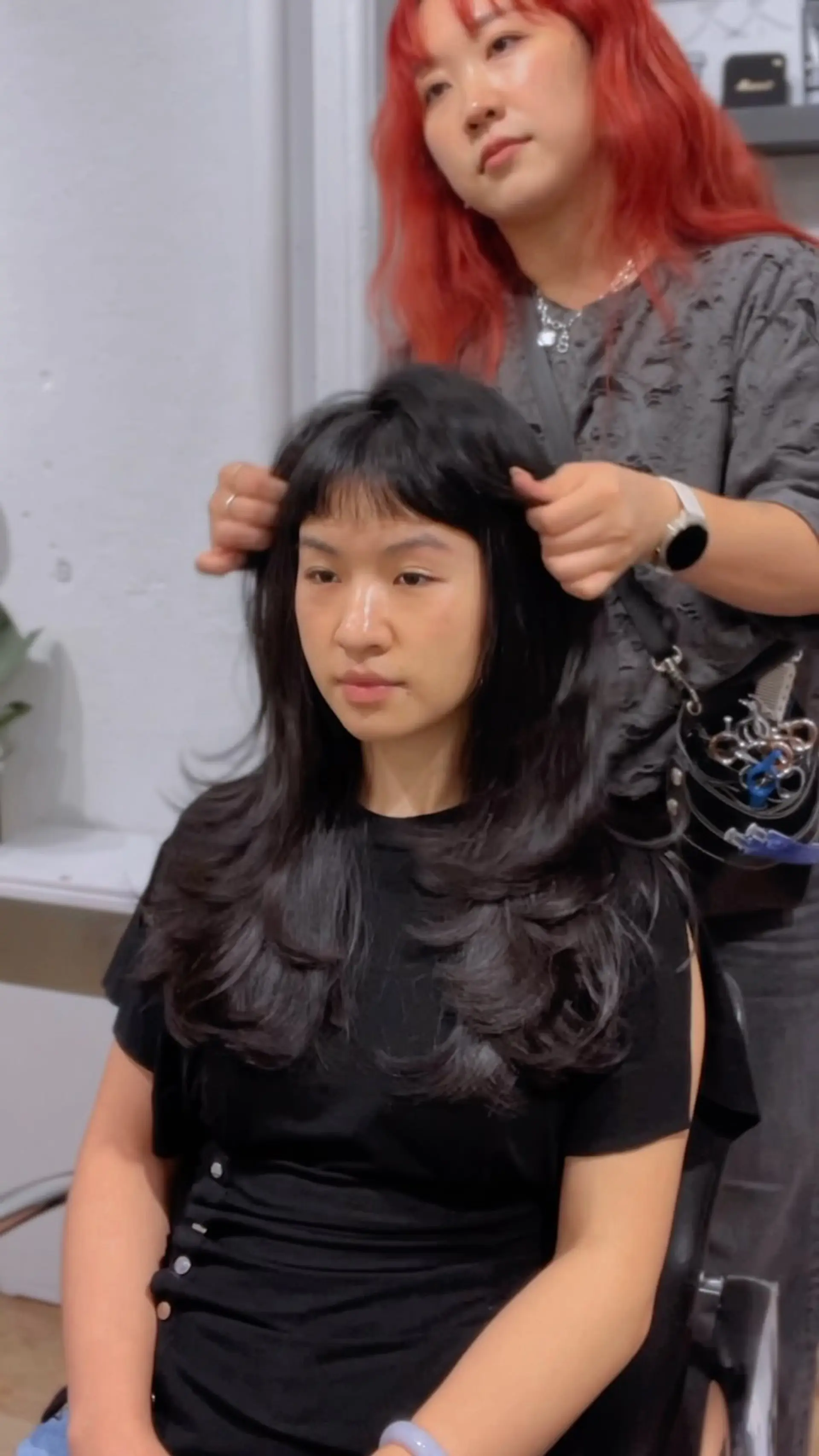A butterfly haircut with voluminous, curved layers and blunt micro baby bangs. 1
