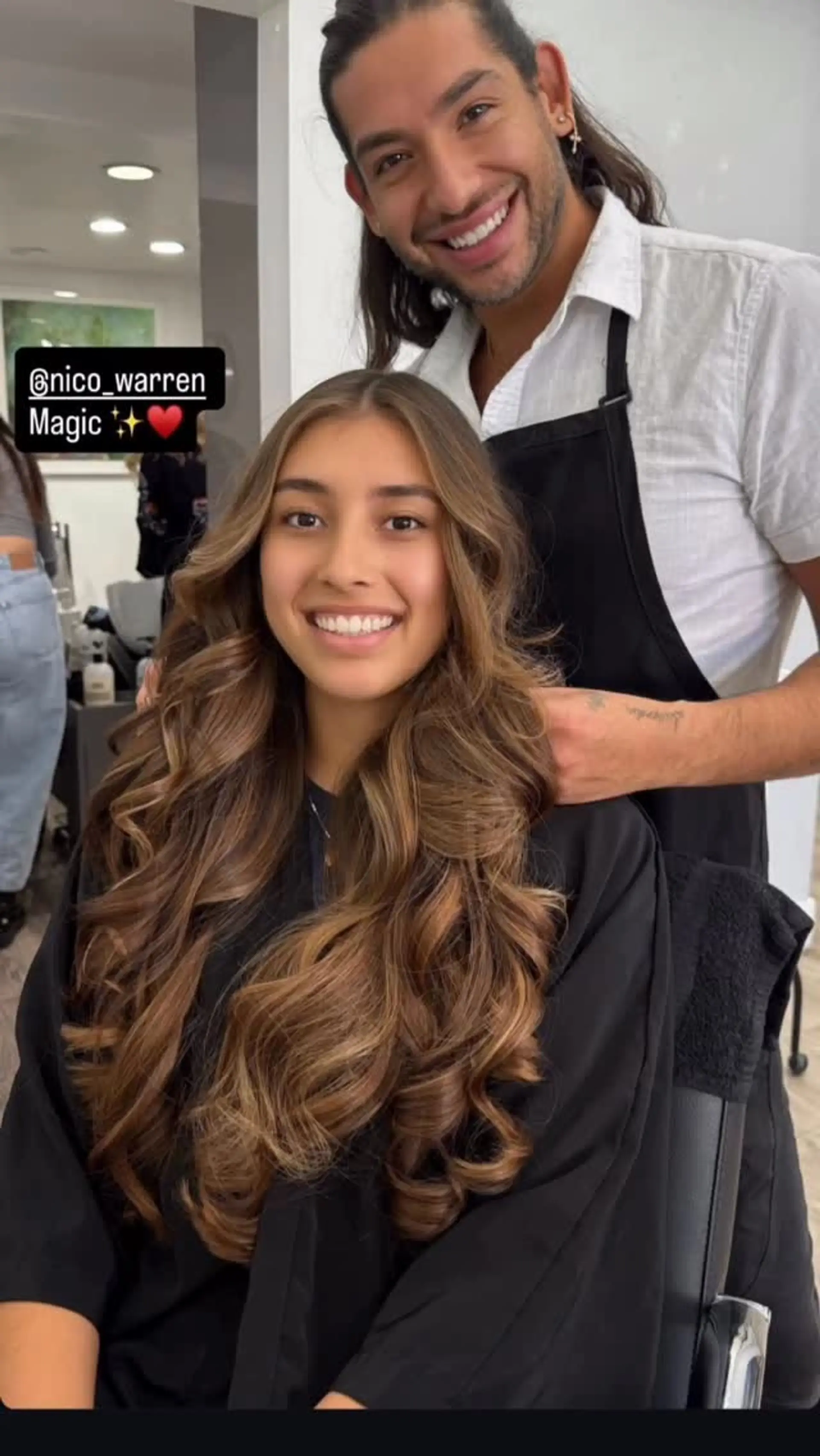 Long layered brunette hair featuring warm caramel balayage highlights styled into voluminous, bouncy waves. 1