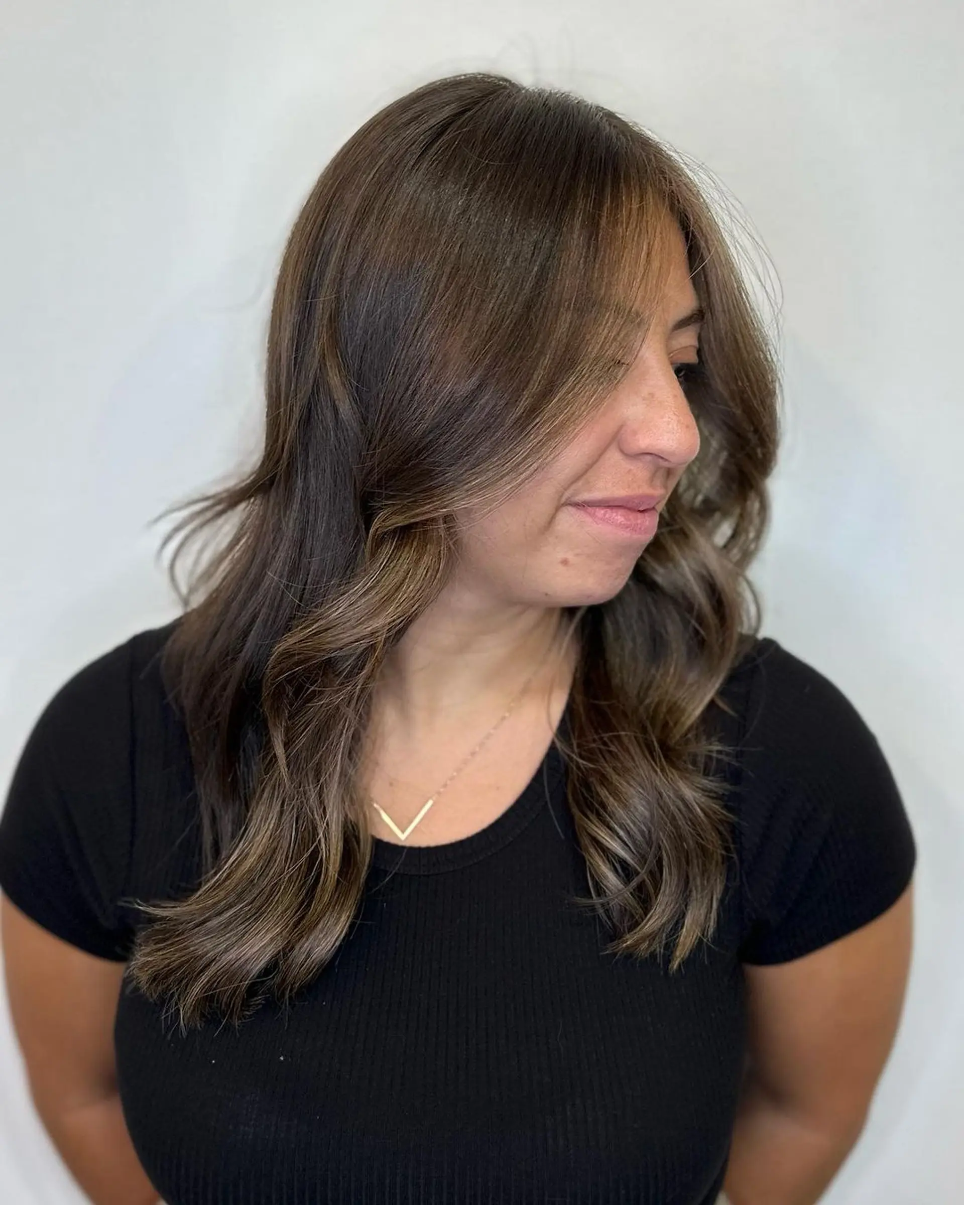 Medium-length wavy hairstyle in rich brown with honey highlights, featuring a side part, loose waves, and face-framing layers.

Color by @simabeautynyc
Cut and style by @juliamannino_hair
 1