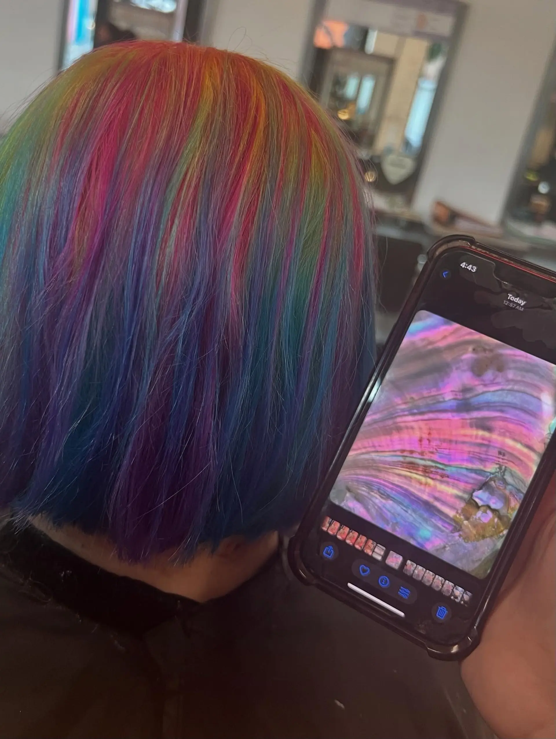 A sleek, chin-length bob featuring an iridescent vivid color melt with ribbons of pink, blue, purple, yellow, and green. 1