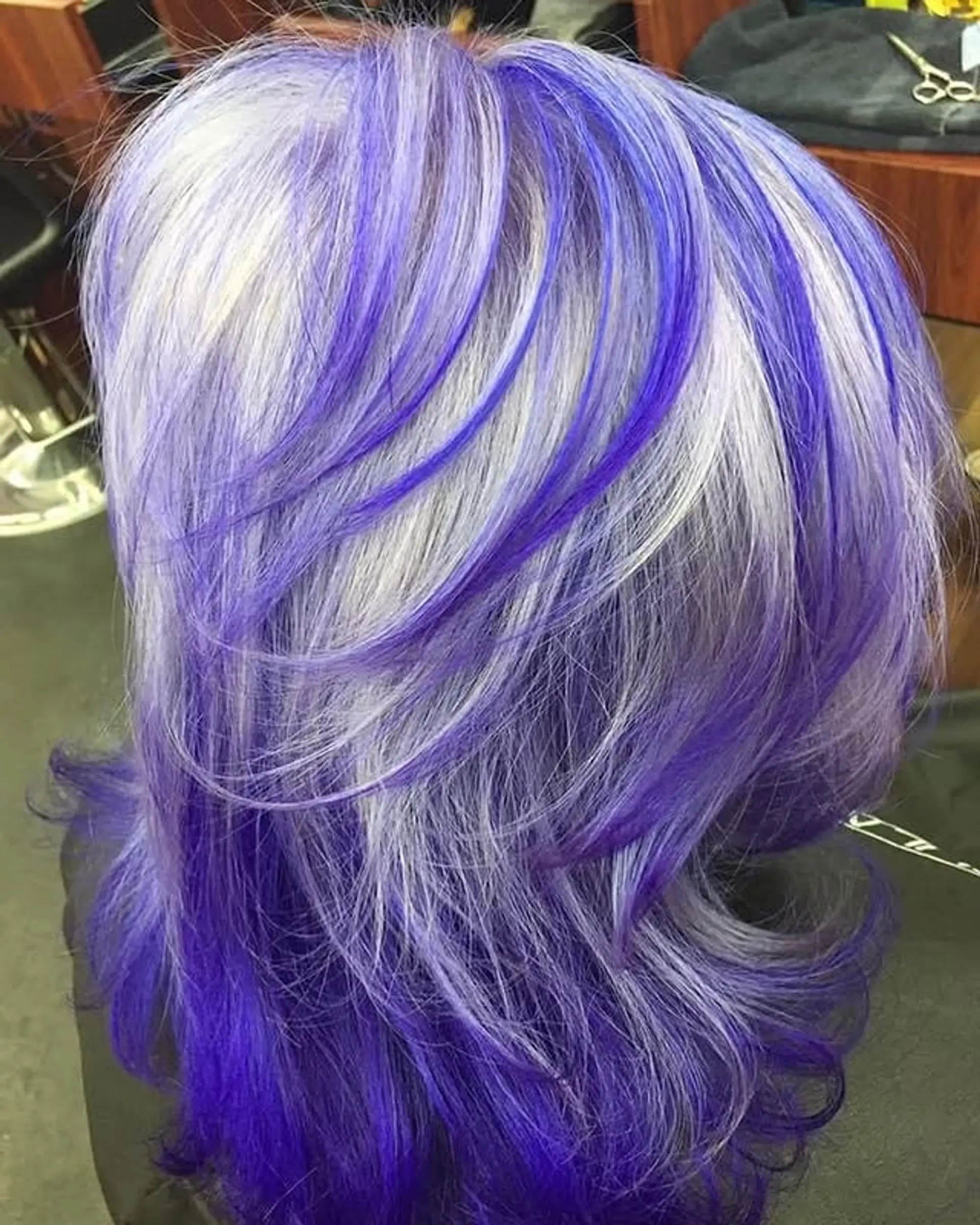 A medium length layered lob with platinum blonde and vibrant violet highlights. 1