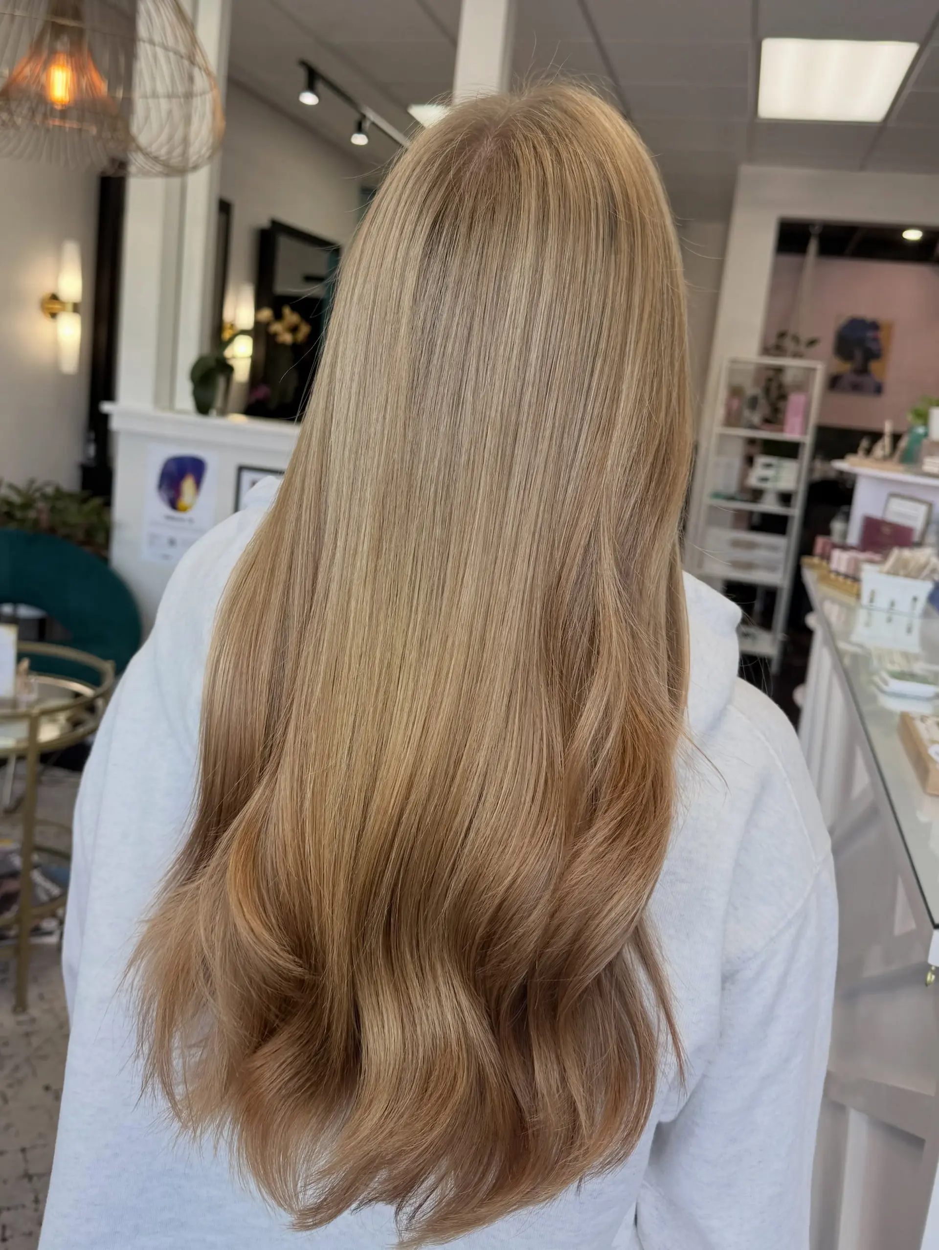 Long golden blonde balayage styled smooth with soft waves at the ends. 1