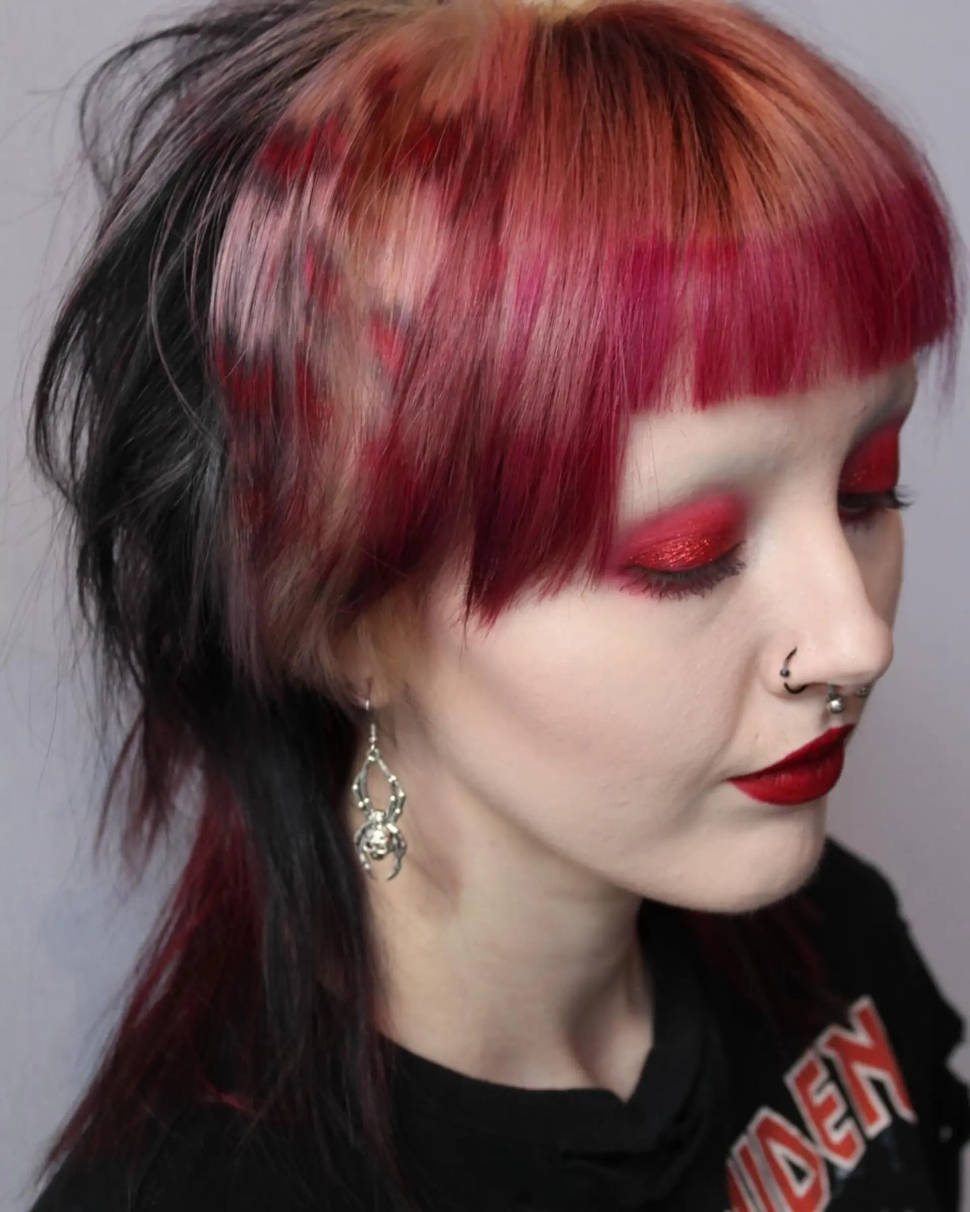 A wolf cut with choppy layers and vibrant red, pink, and black colors. 2