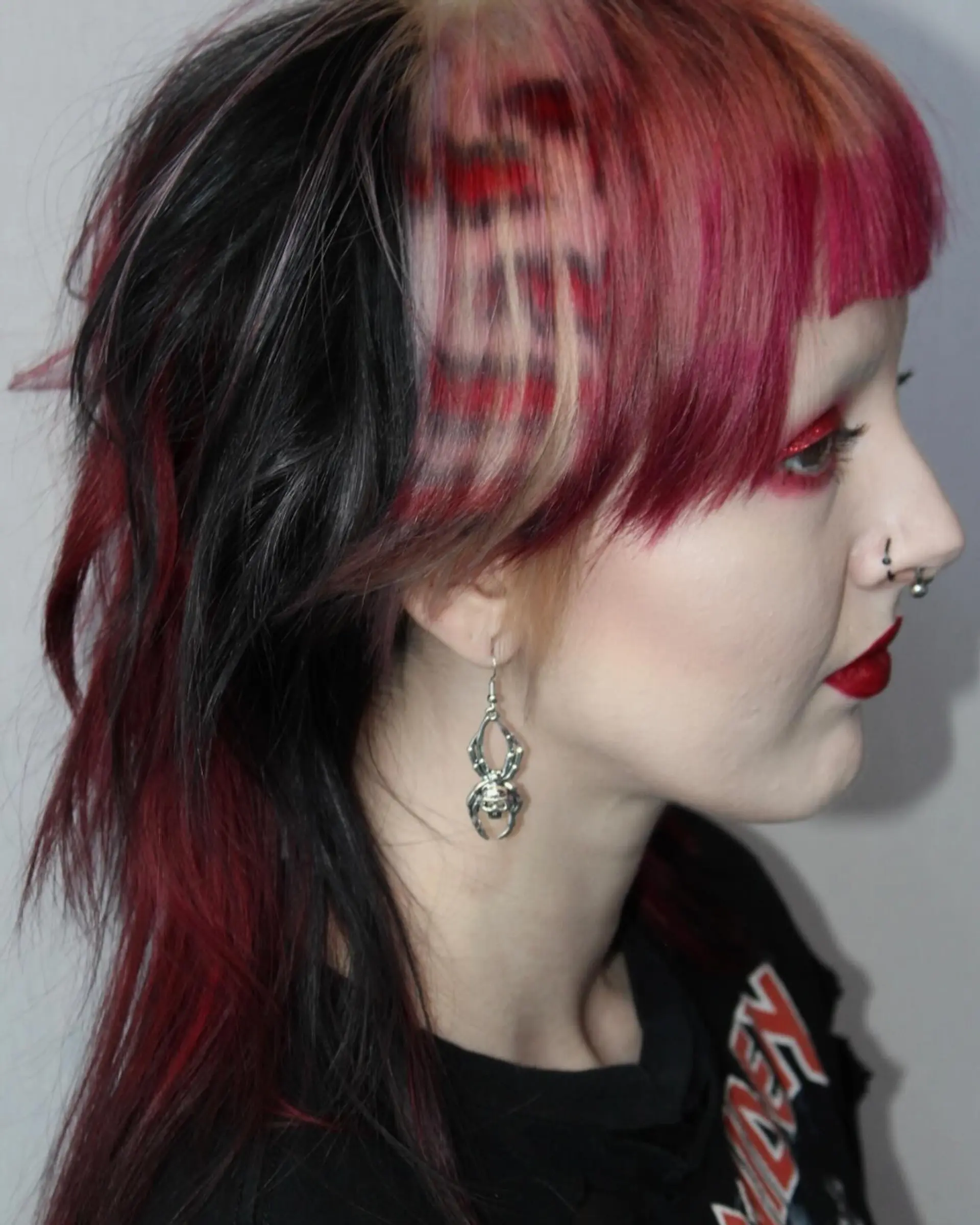 A wolf cut with choppy layers and vibrant red, pink, and black colors. 3