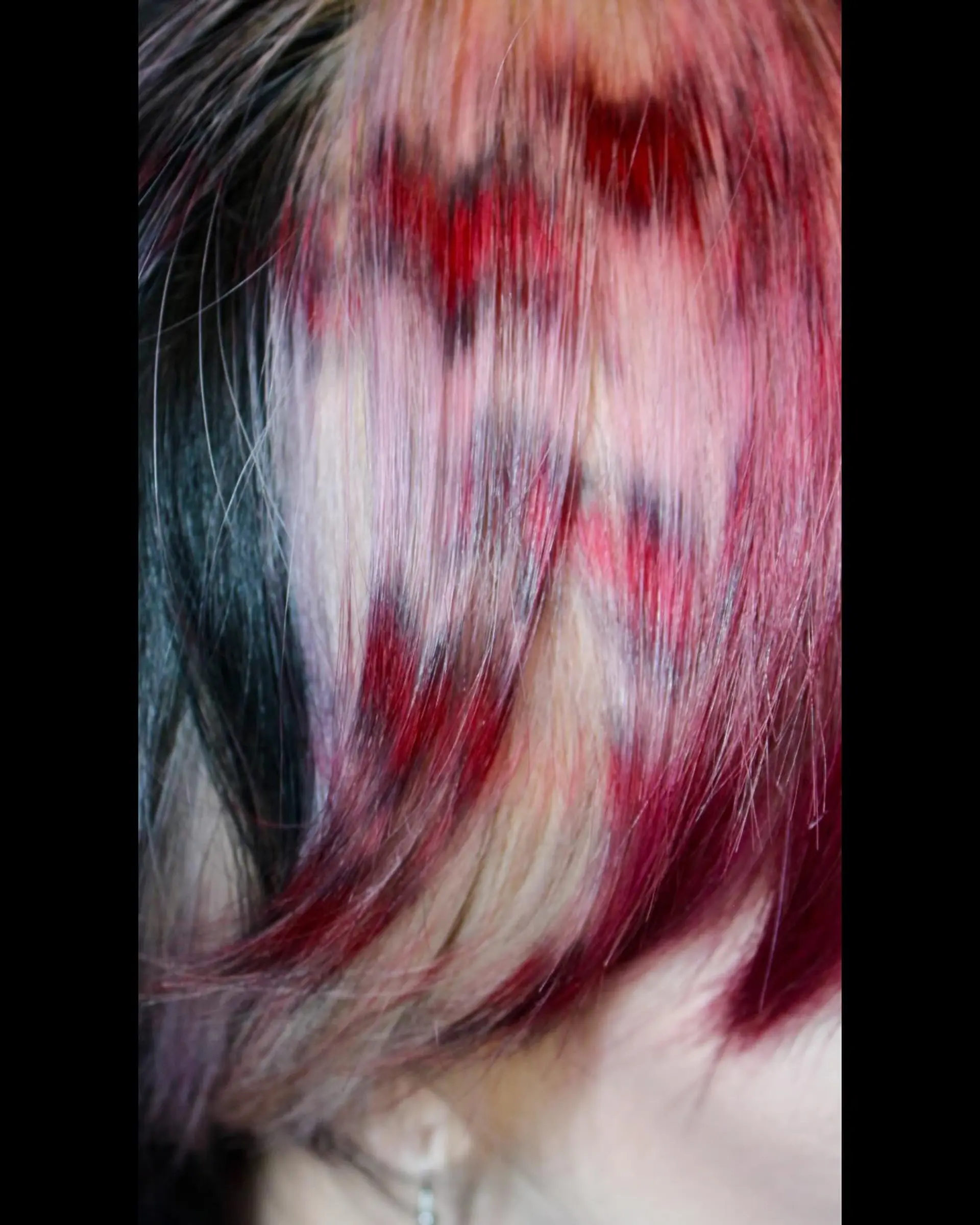 A wolf cut with choppy layers and vibrant red, pink, and black colors. 4