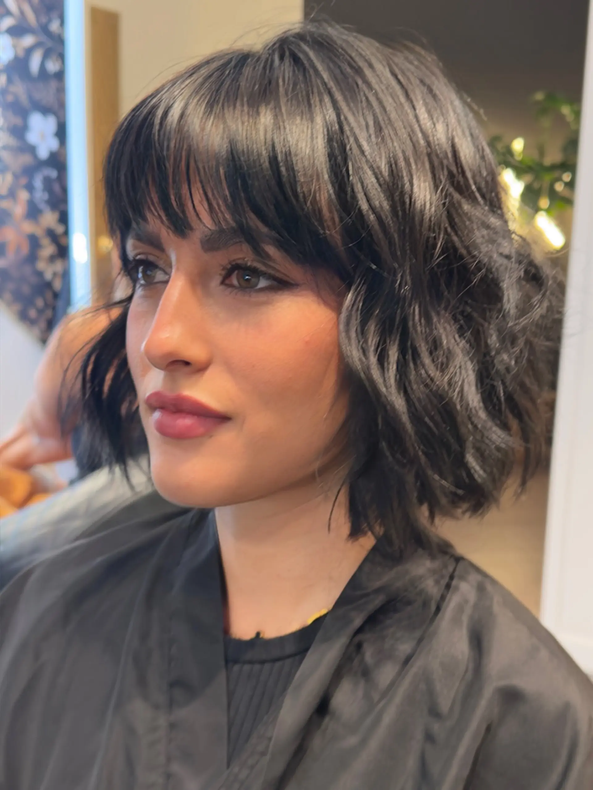 A stylish chin-length wavy bob featuring soft texture and a full, piecey fringe. 1