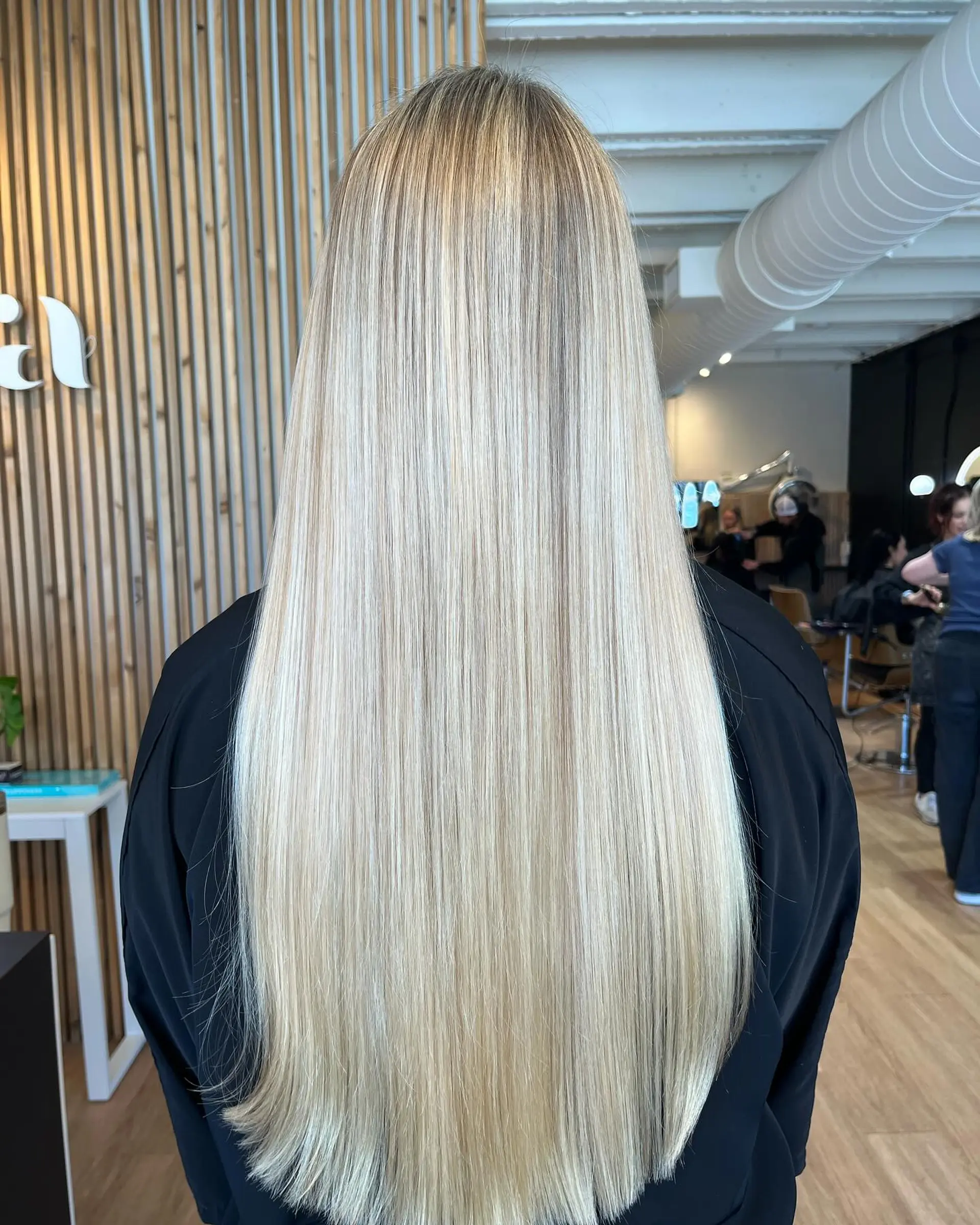 Extra-long, pin-straight blonde hair with finely woven highlights and a silky, sleek finish. 1