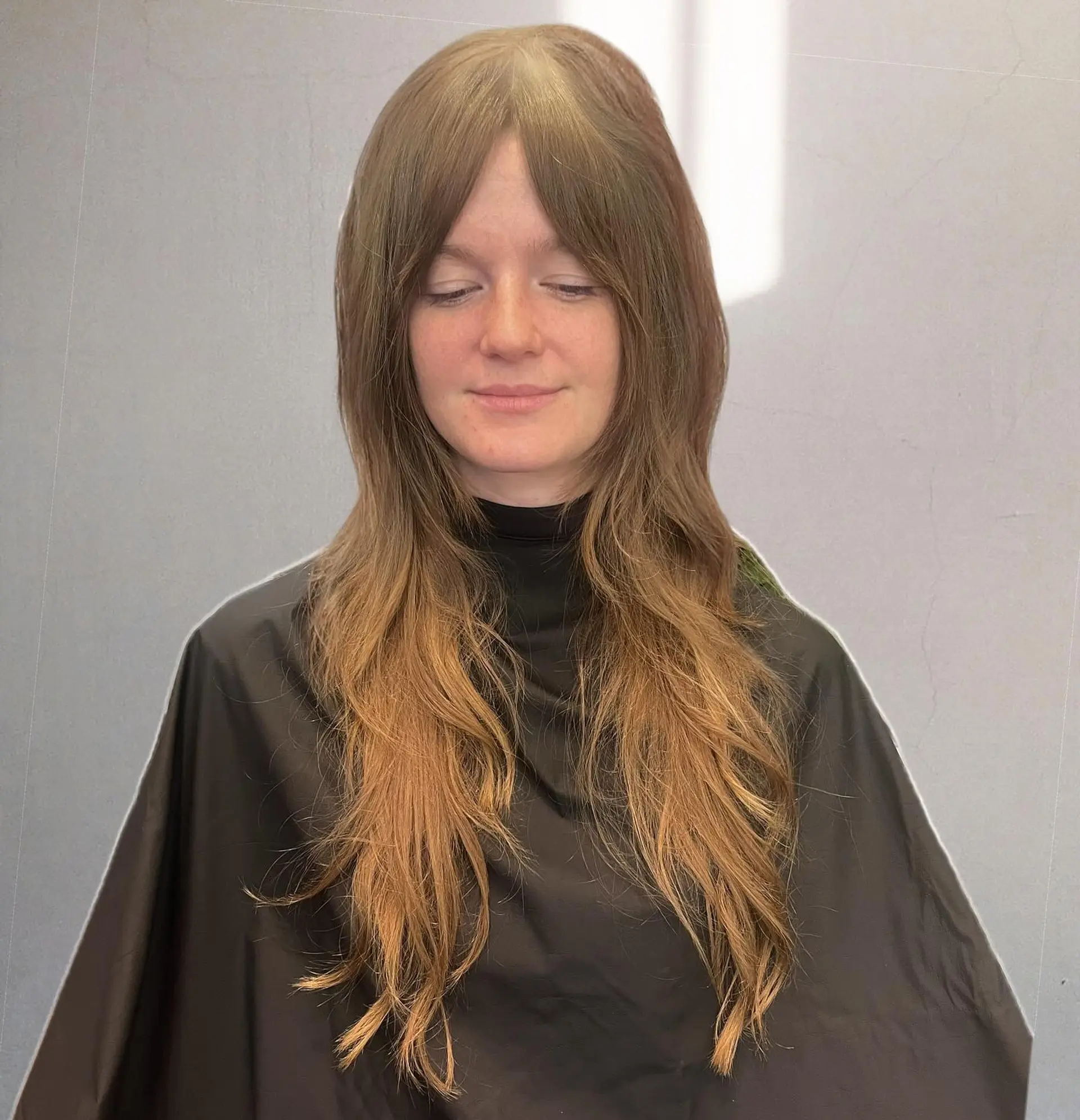 Long fine hair cut into feathered, face-framing shag layers paired with center-parted curtain bangs. 1