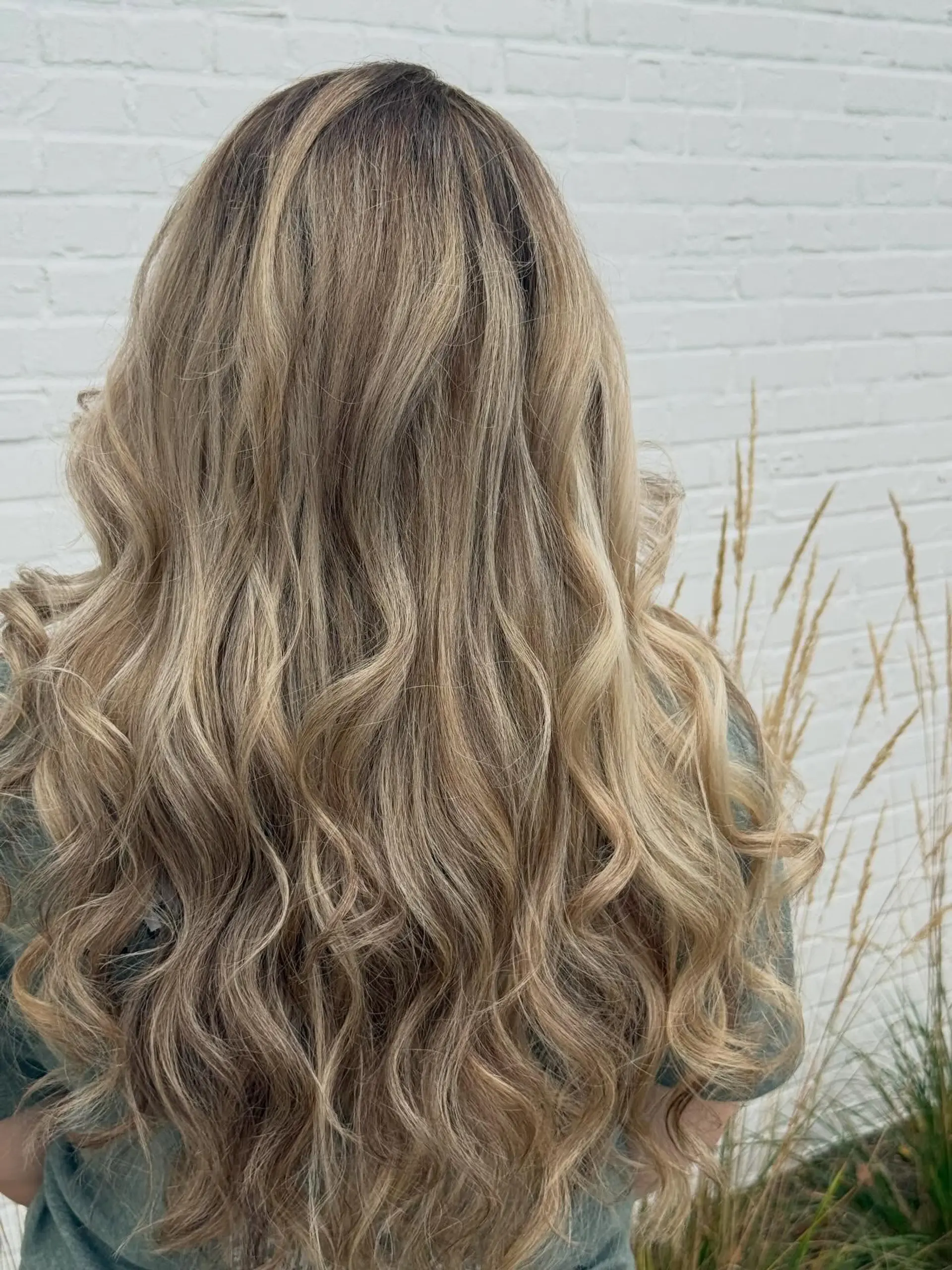 Long beige blonde hair with subtle lowlights and dimensional tones, styled in loose cascading waves. 1